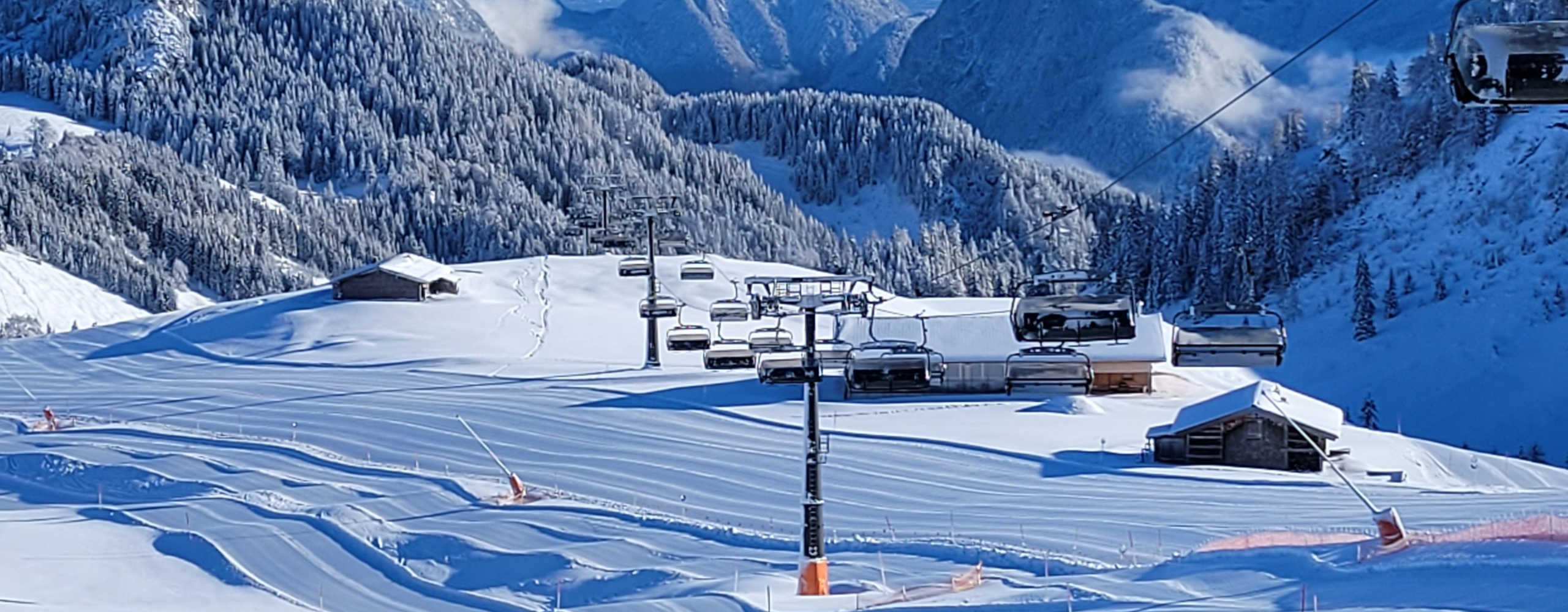 Groomed ski slopes and a chairlift in the Almenwelt Lofer against a stunning winter mountain backdrop.