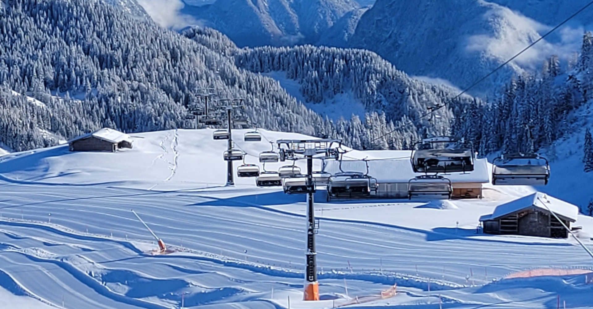 Groomed ski slopes and a chairlift in the Almenwelt Lofer against a stunning winter mountain backdrop.