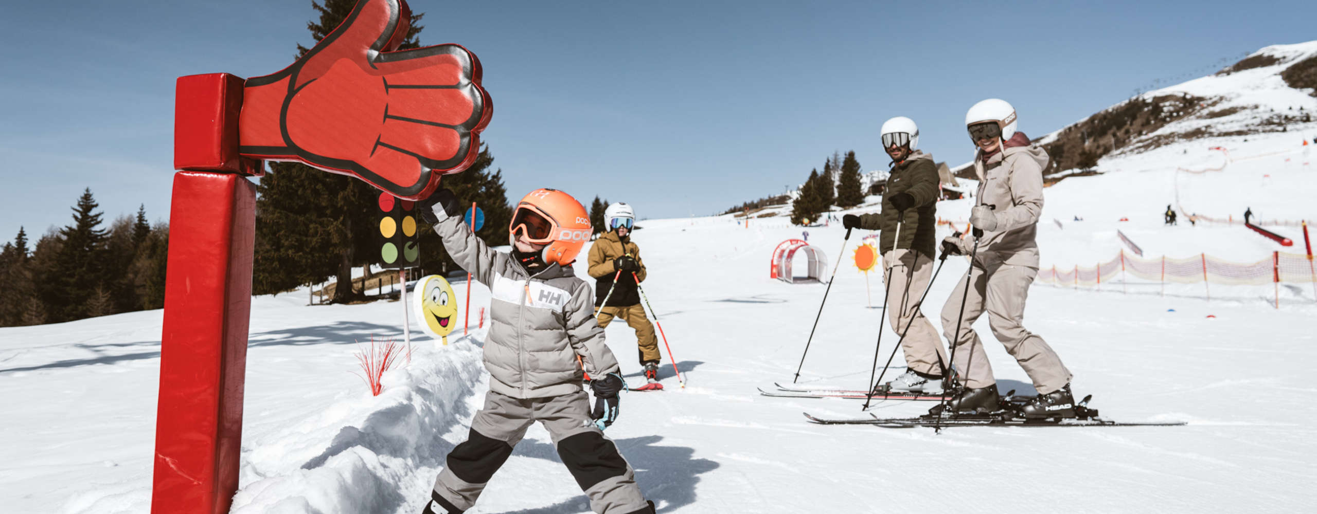 Familie im Kinder-Skigelände in Lienz in Osttirol mit spielerischen Lernstationen im Schnee.