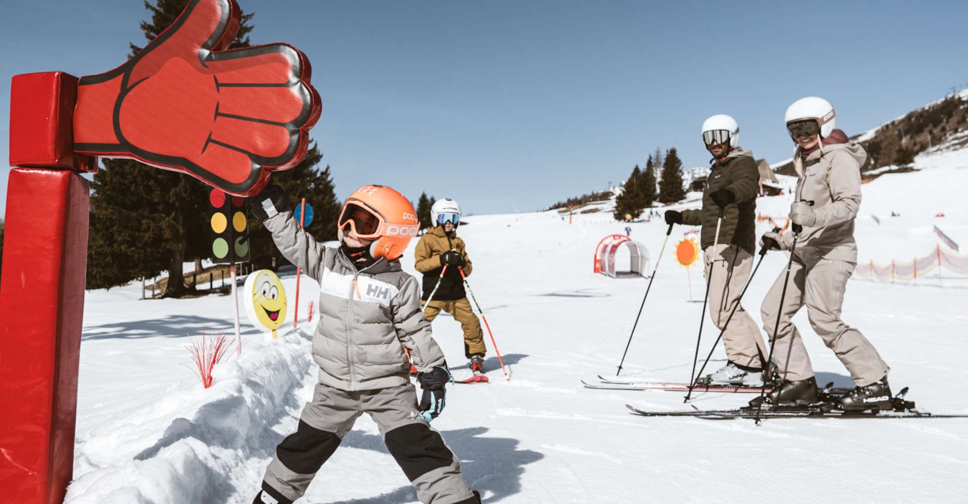 Familie im Kinder-Skigelände in Lienz in Osttirol mit spielerischen Lernstationen im Schnee.