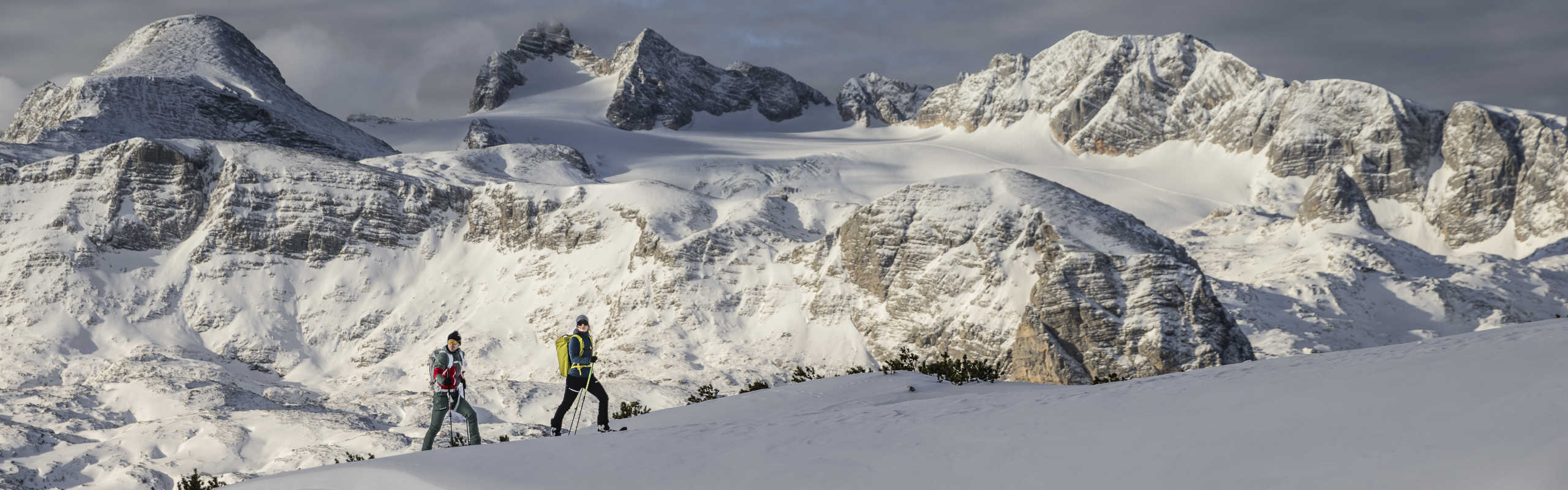 Winter hike against the backdrop of the snow-covered Dachstein massif in Upper Austria.