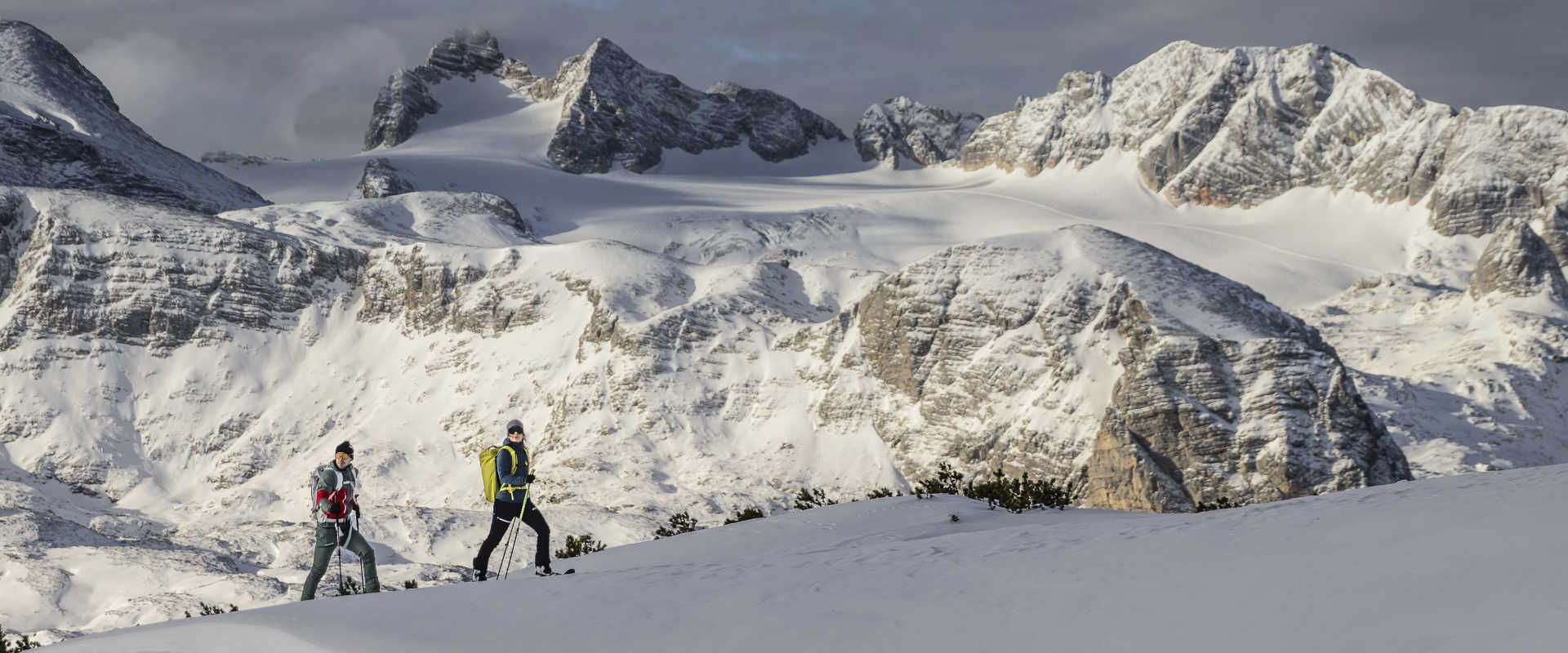 Winter hike against the backdrop of the snow-covered Dachstein massif in Upper Austria.