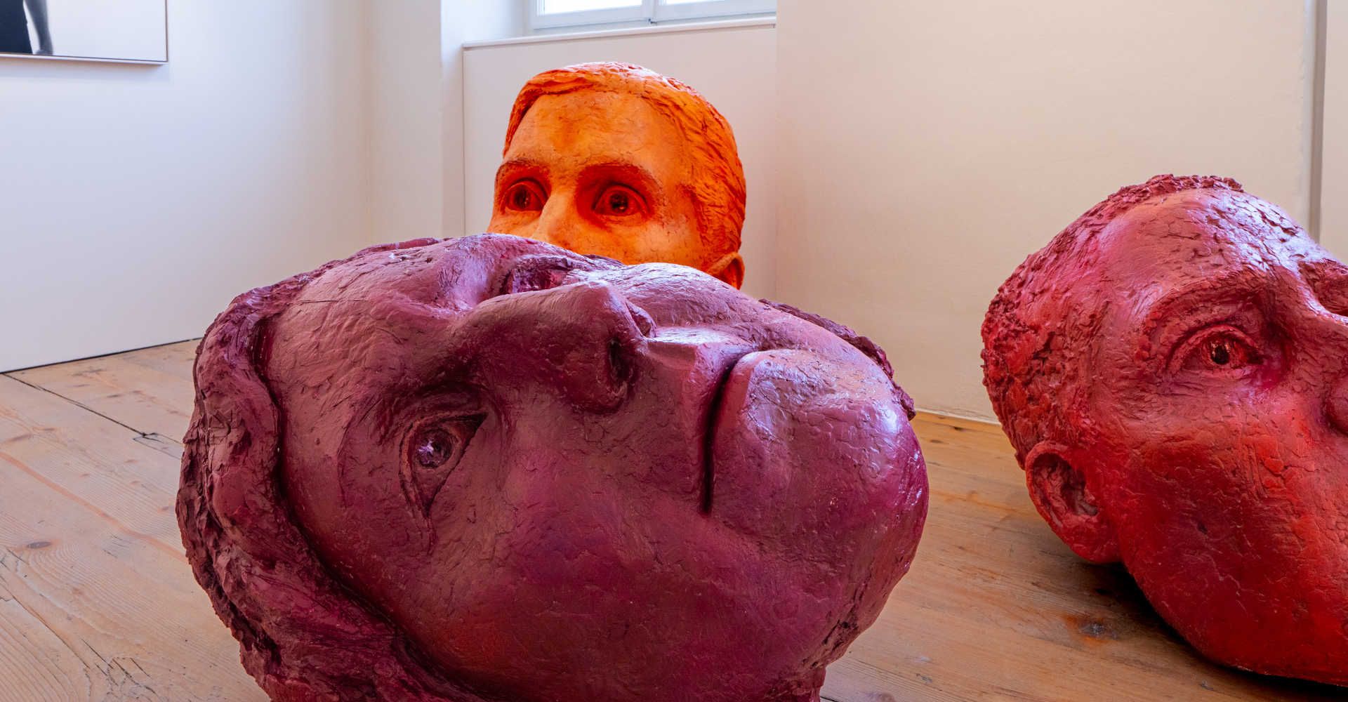3 Farbige Kopfstatuen am Boden liegend