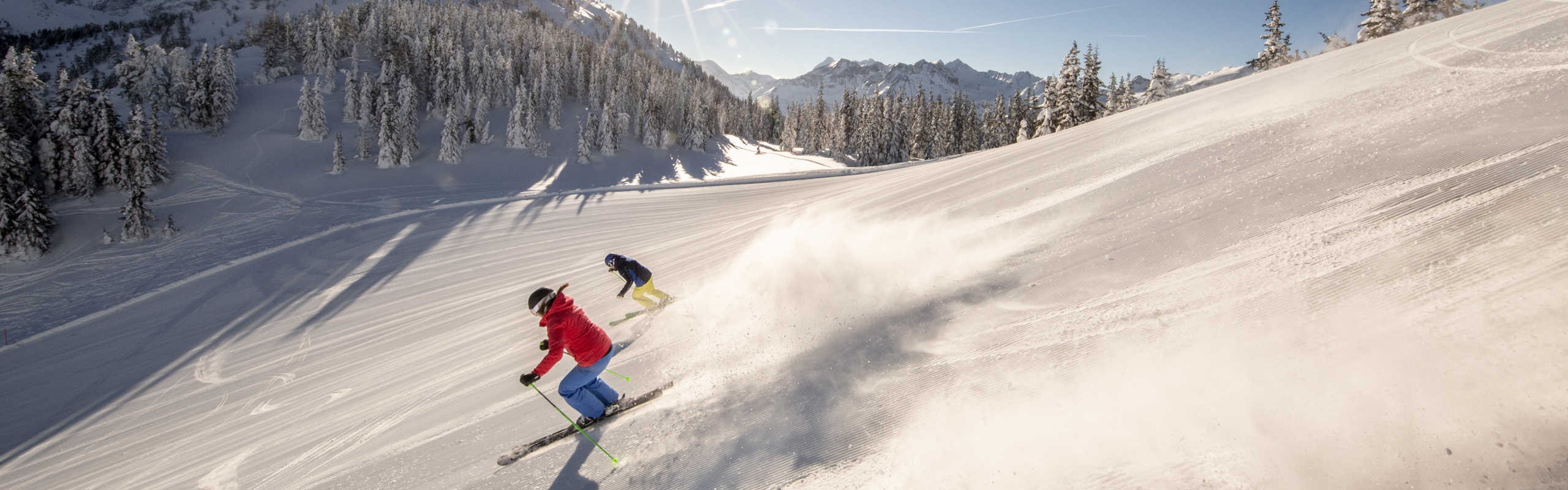Two skiers on the Planai in Schladming carving on a freshly groomed slope in the Schladming-Dachstein region.