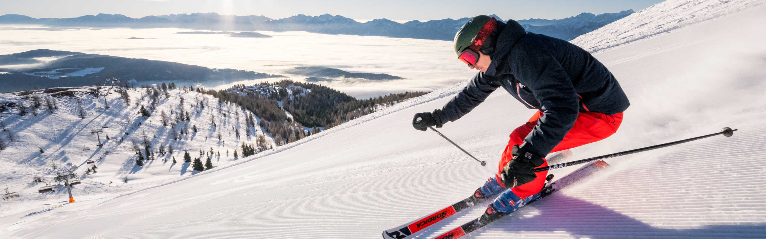 Skiing on the Gerlitzen Alpe with a view of the sea of fog and the wintery Carinthian Alps.