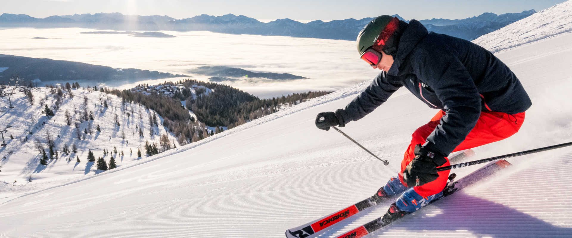 Skiing on the Gerlitzen Alpe with a view of the sea of fog and the wintery Carinthian Alps.