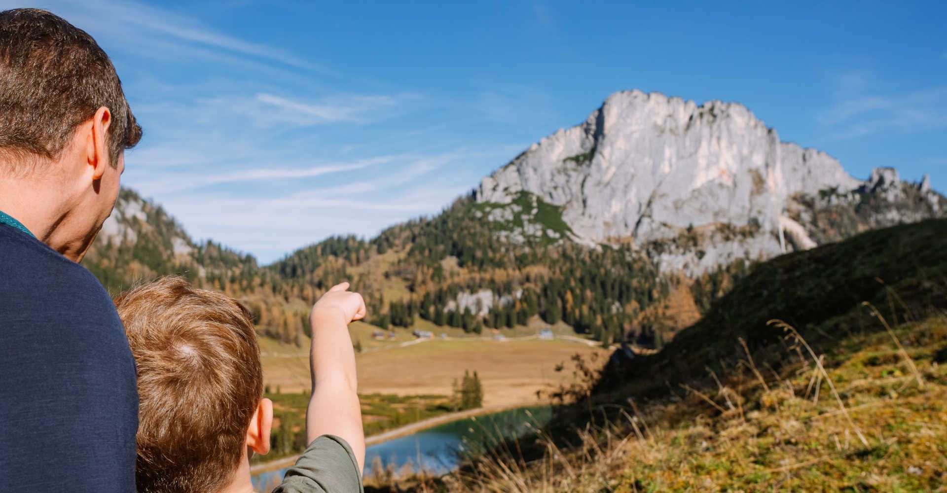 Vater und Sohn sehen auf die Berge im Sommer