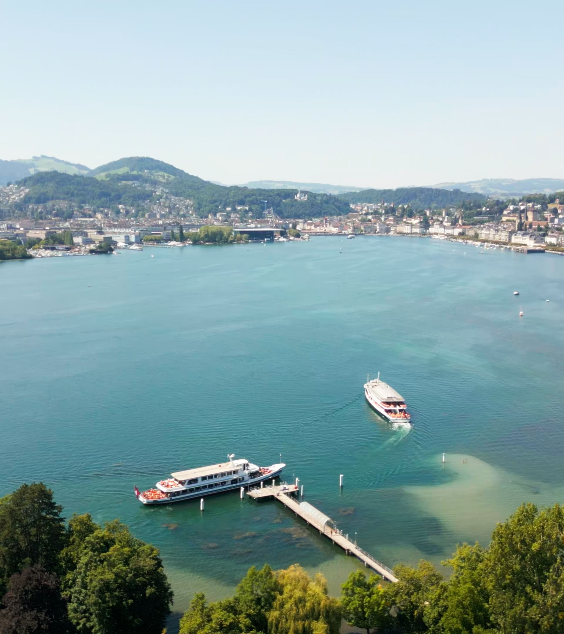 Drone view of the Transport Museum pier on Lake Lucerne with boats and Lucerne Bay.