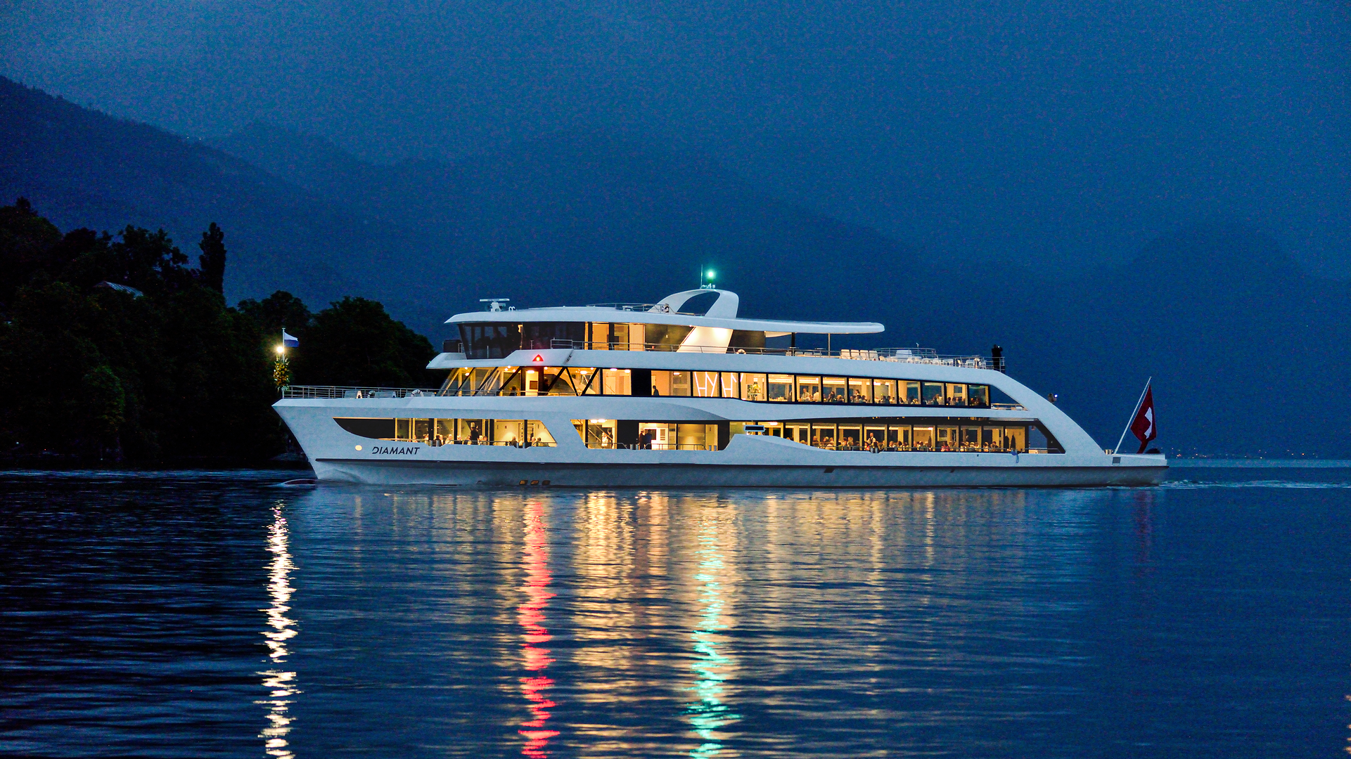Motorschiff Diamant bei Nacht auf dem Vierwaldstättersee mit beleuchtetem Innenraum.
