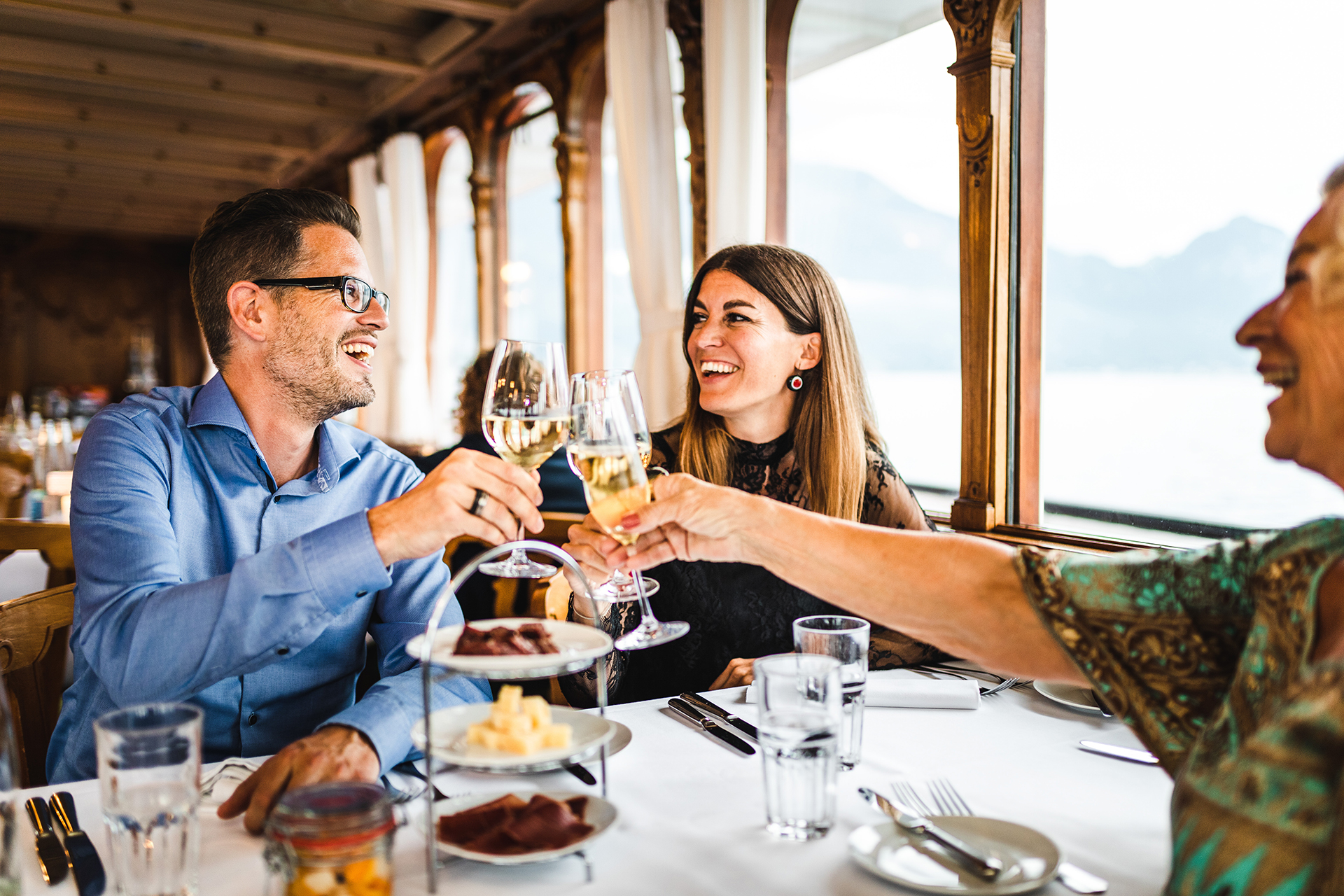 Les hôtes du bateau à vapeur Wine and Dine lèvent leur verre ensemble au restaurant du bateau.