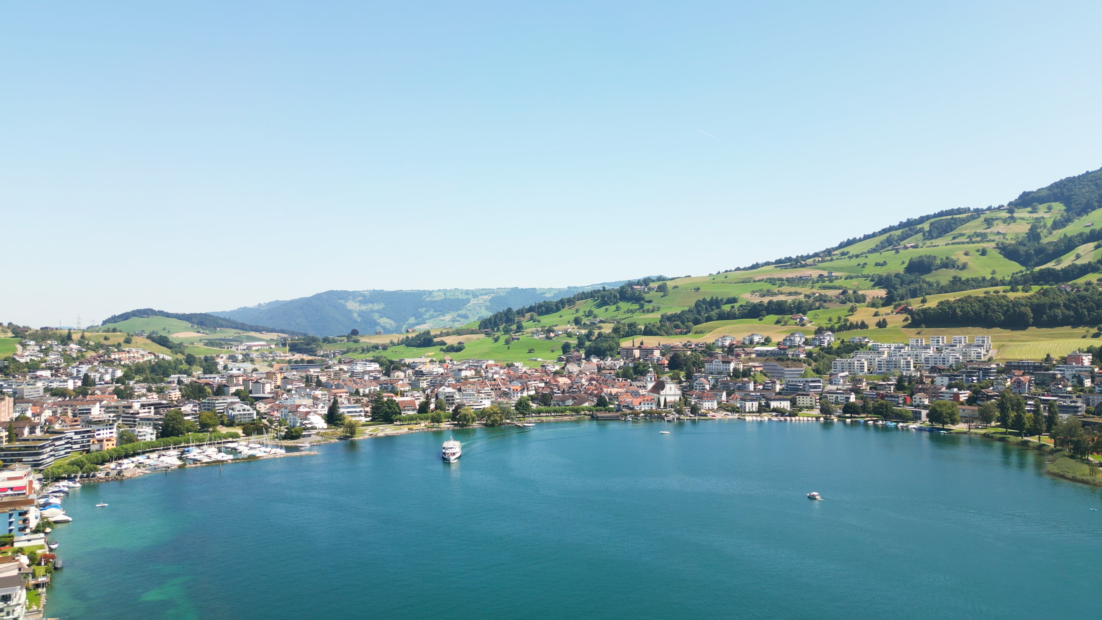 Vue aérienne de Küssnacht au bord du lac avec collines et paysage alpin.