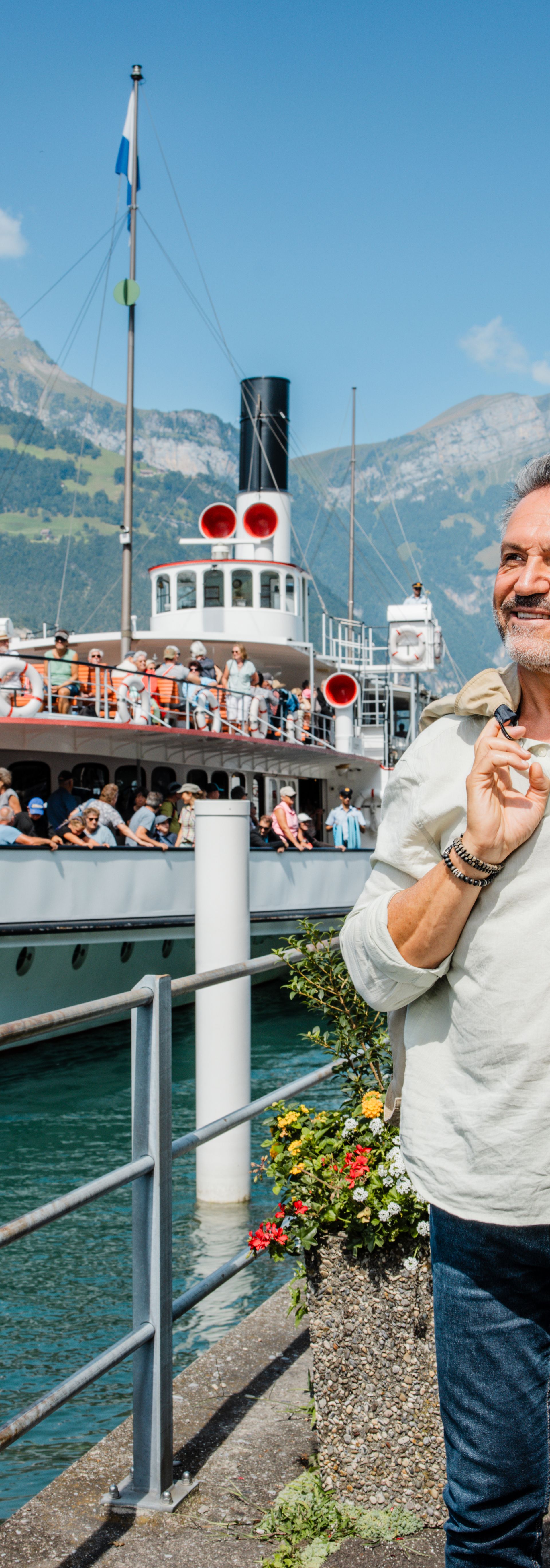 Im Vordergrund fährt der Zug und im Hintergrund sieht man das Dampfschiff. Beides vereint für die Reise mit dem Gopex