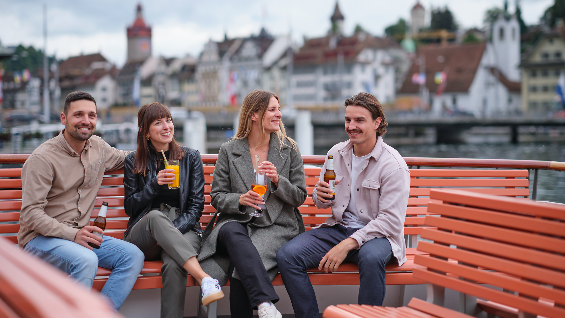 Friends enjoying drinks during an after-work cruise on Lake Lucerne