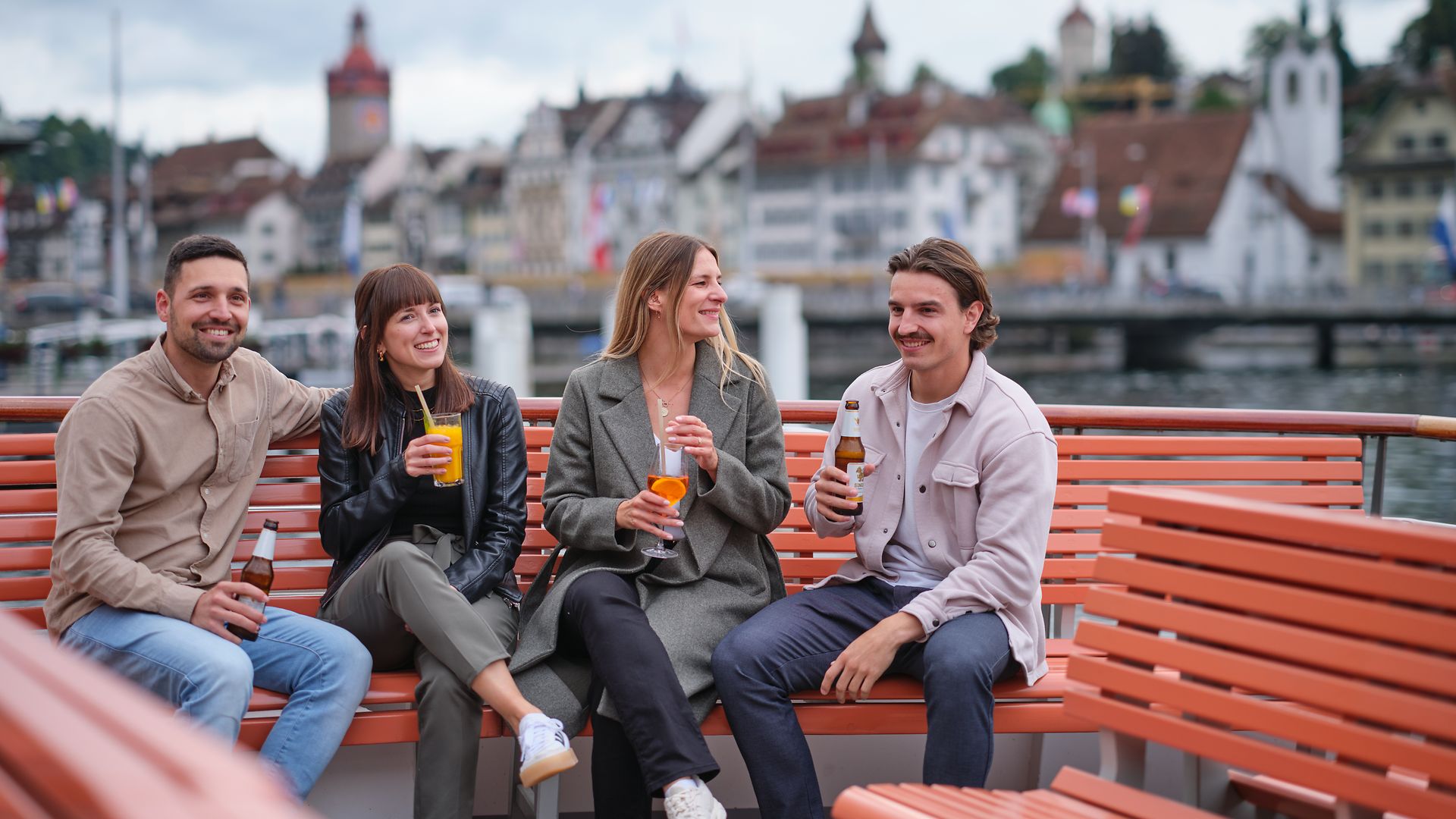 Friends enjoying drinks during an after-work cruise on Lake Lucerne