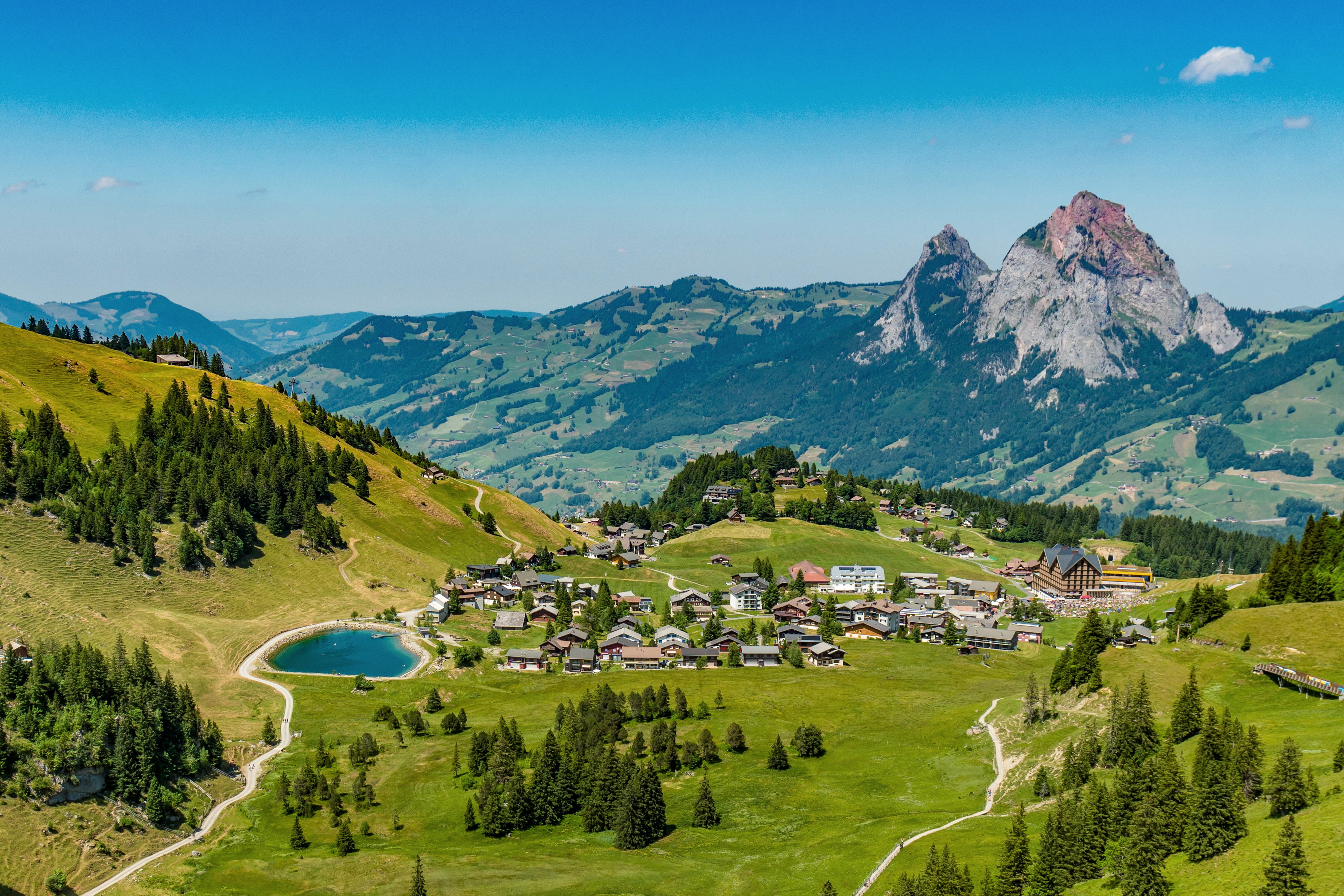 Bergdorf Stoos mit alpiner Landschaft, kleinem Bergsee und Blick auf markante Gipfel.