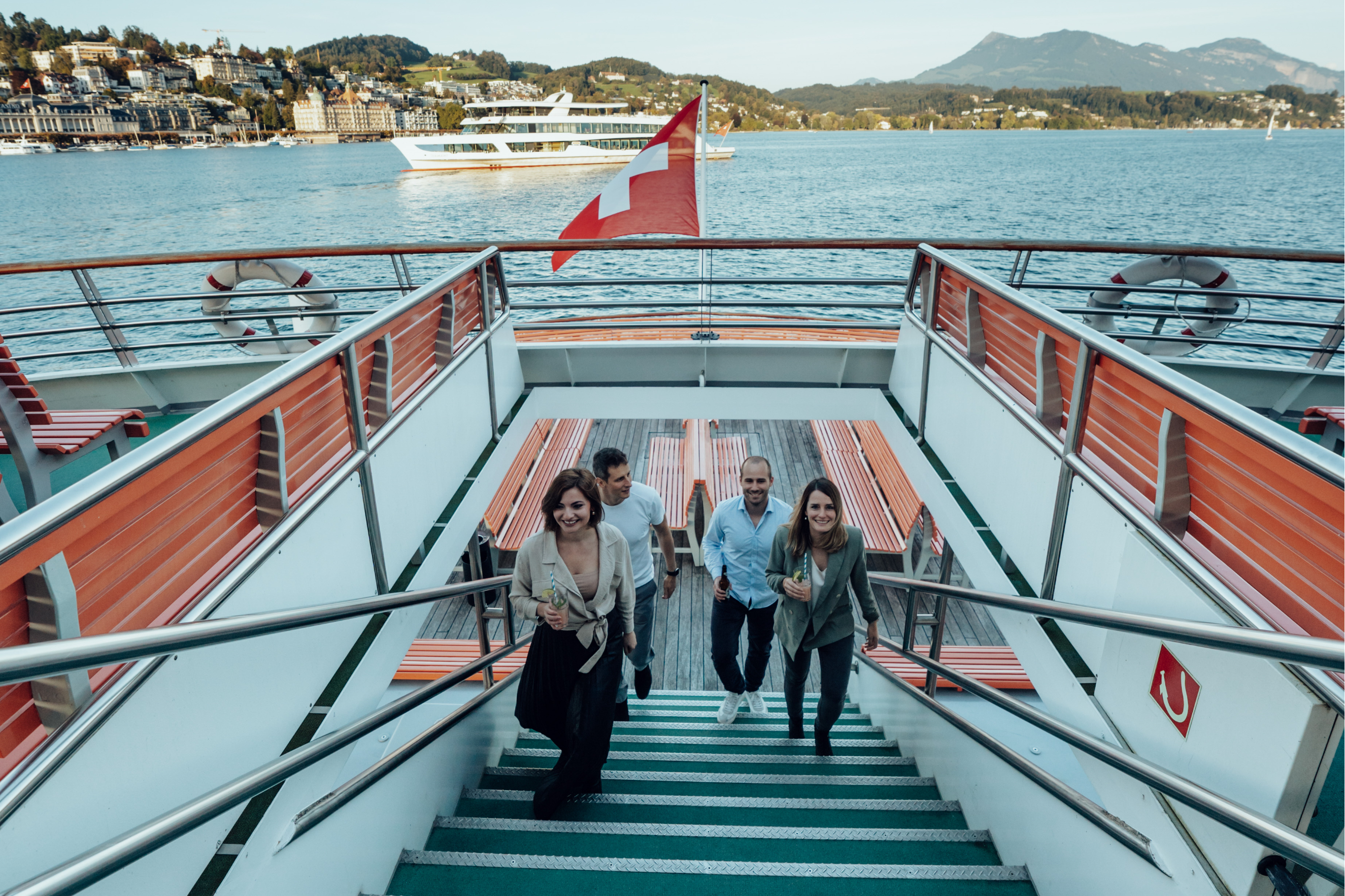 Passagiere betreten das Oberdeck eines Schiffes auf dem Vierwaldstättersee während der Fahrt zwischen Luzern und Vitznau