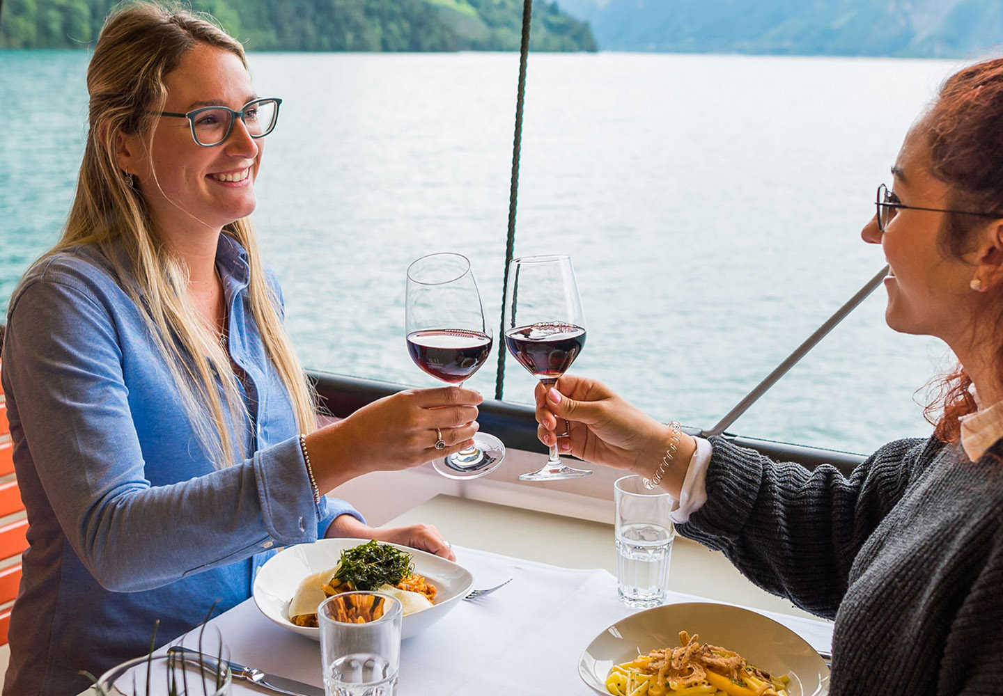 Eating on the lunch boat - Two women enjoy the delicious food on the steamboat and toast together.