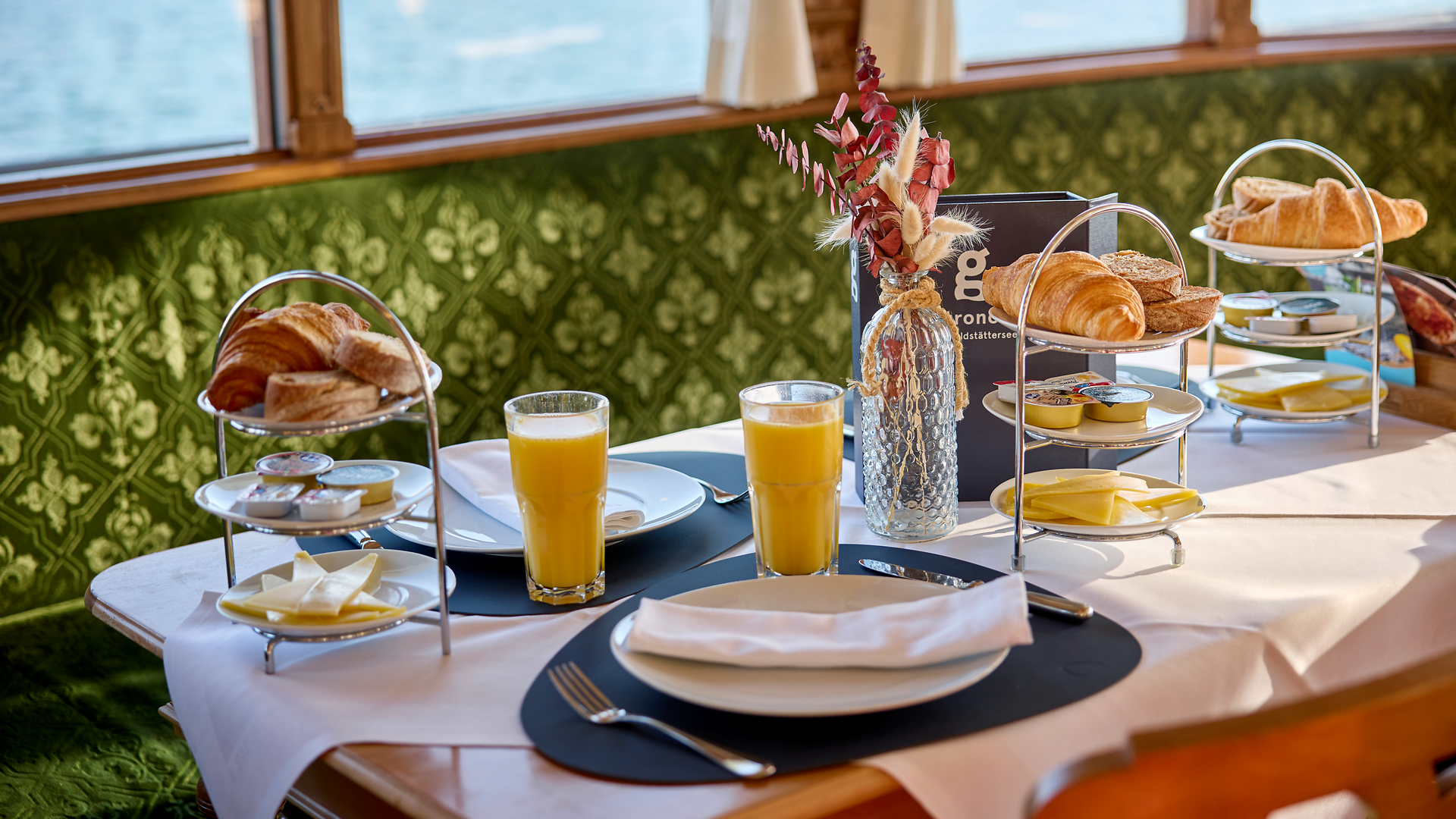 Breakfast with croissants, orange juice and coffee served on a table aboard a scheduled Lake Lucerne vessel