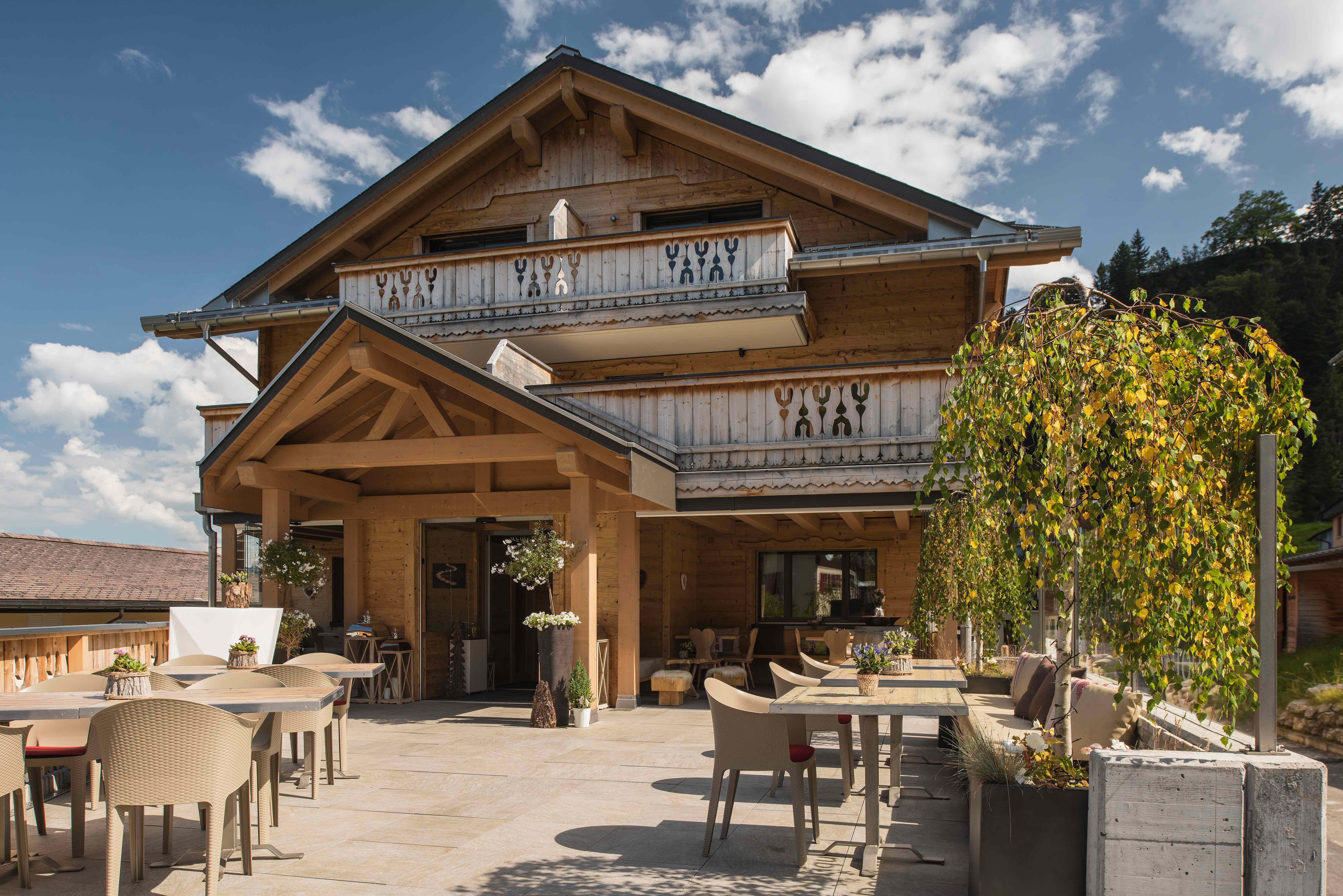 Bergrestaurant mit Terrasse und Sitzplätzen vor dem Gebäude in alpiner Landschaft.