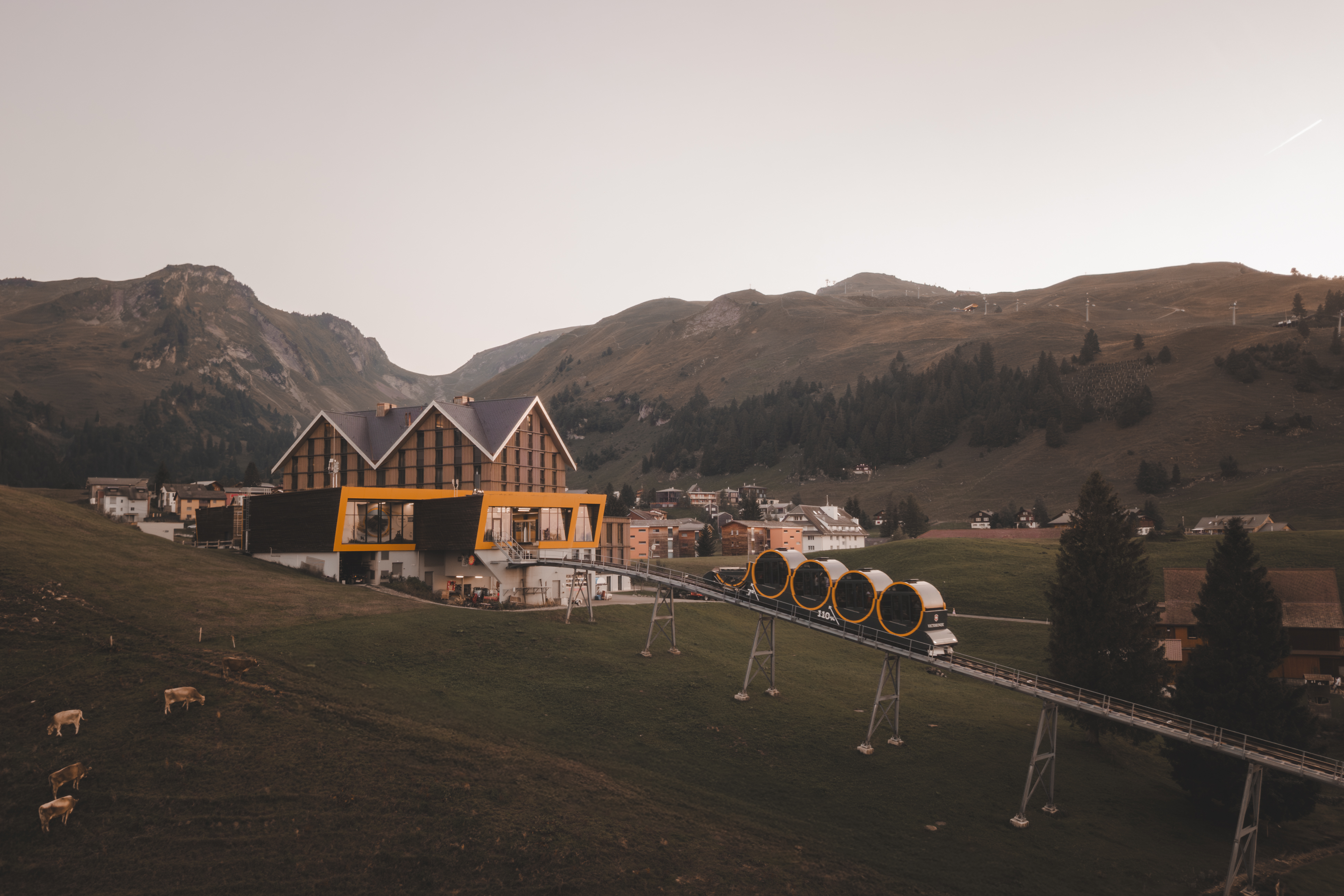 Mountain station of the Stoos funicular with modern architecture on the plateau, surrounded by alpine landscape.