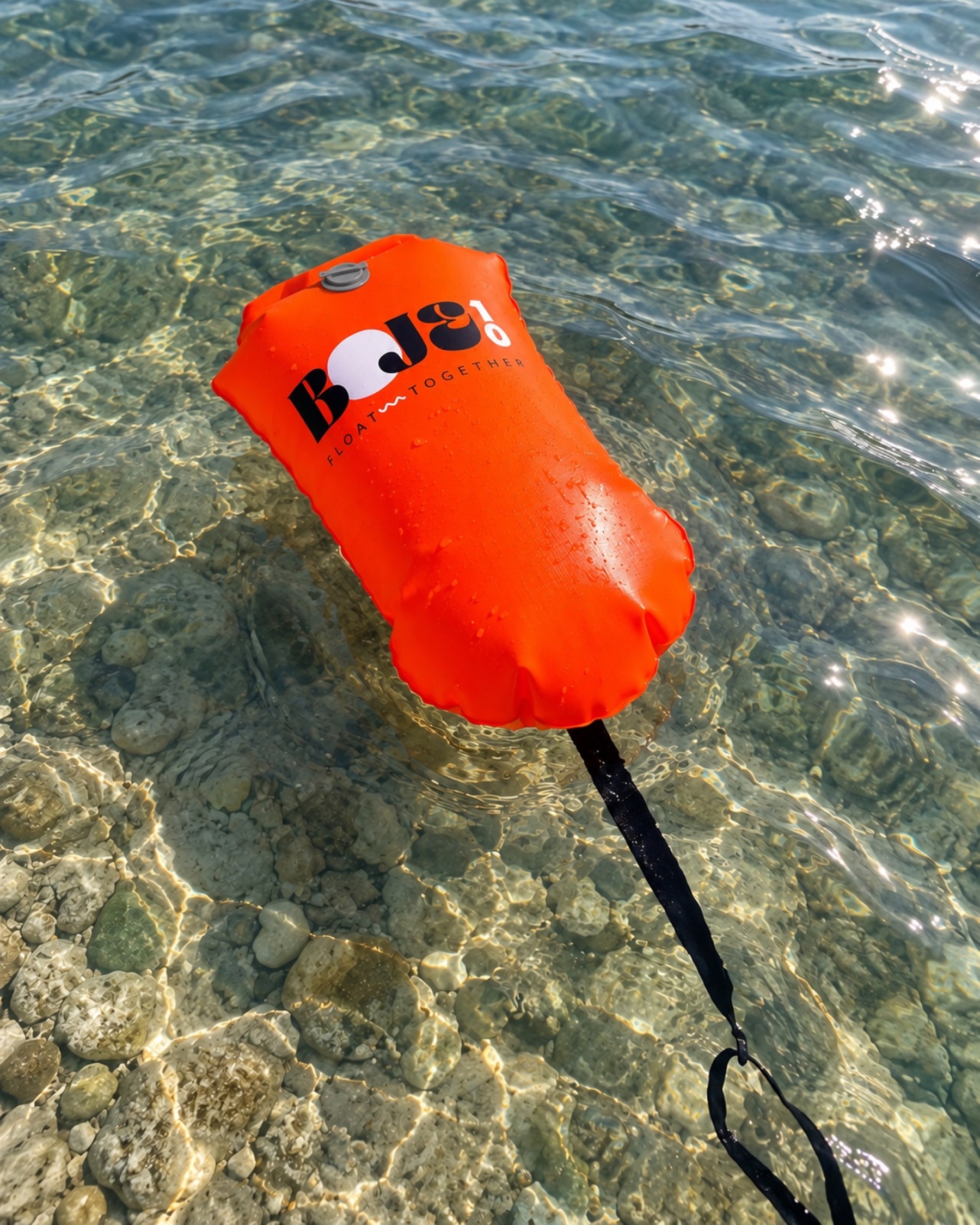 Orange Boje10 Schwimmboje mit flachem grauem Ventil schwimmt in klarem Seewasser