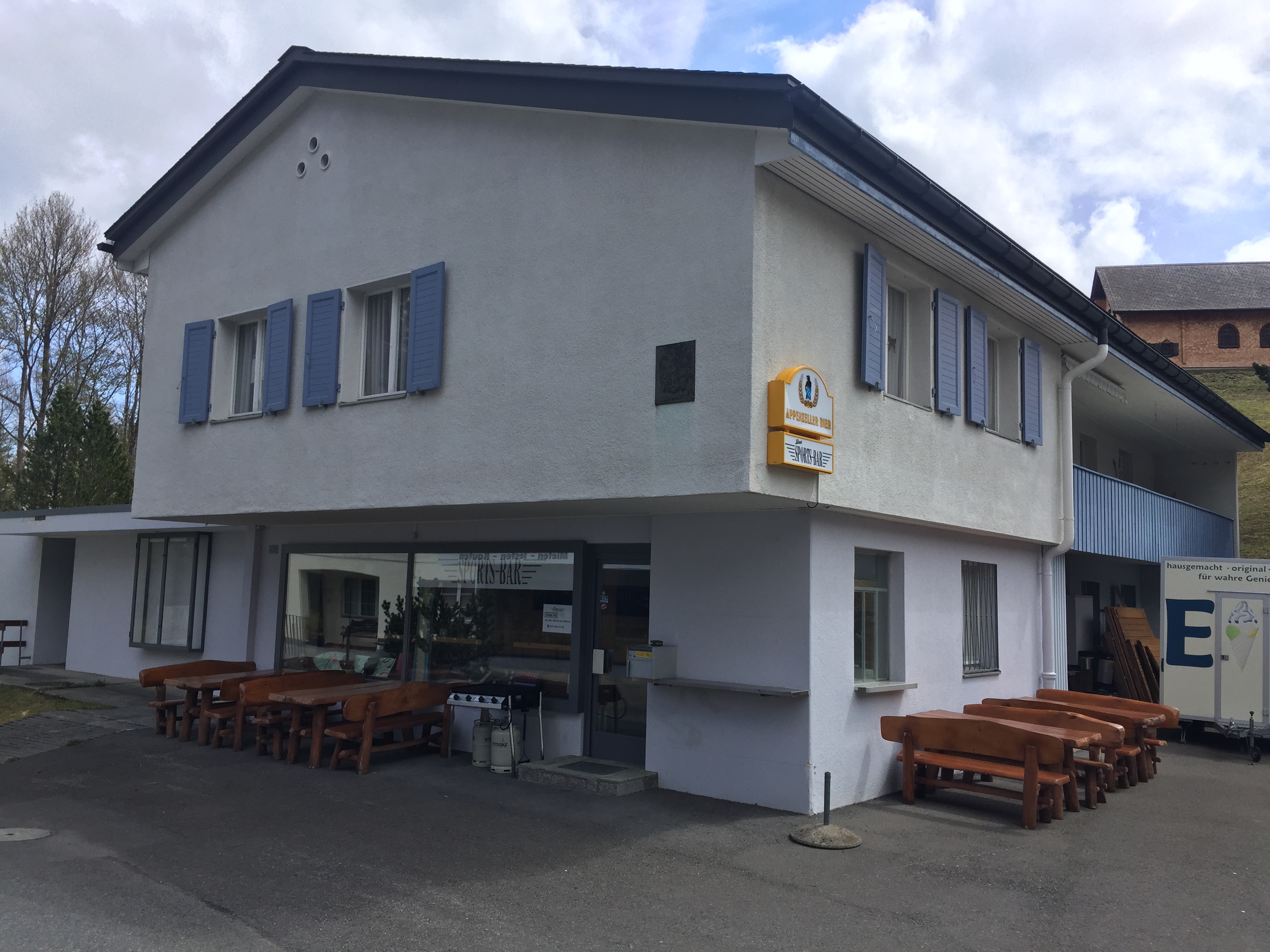 Building with outdoor seating in an alpine setting.