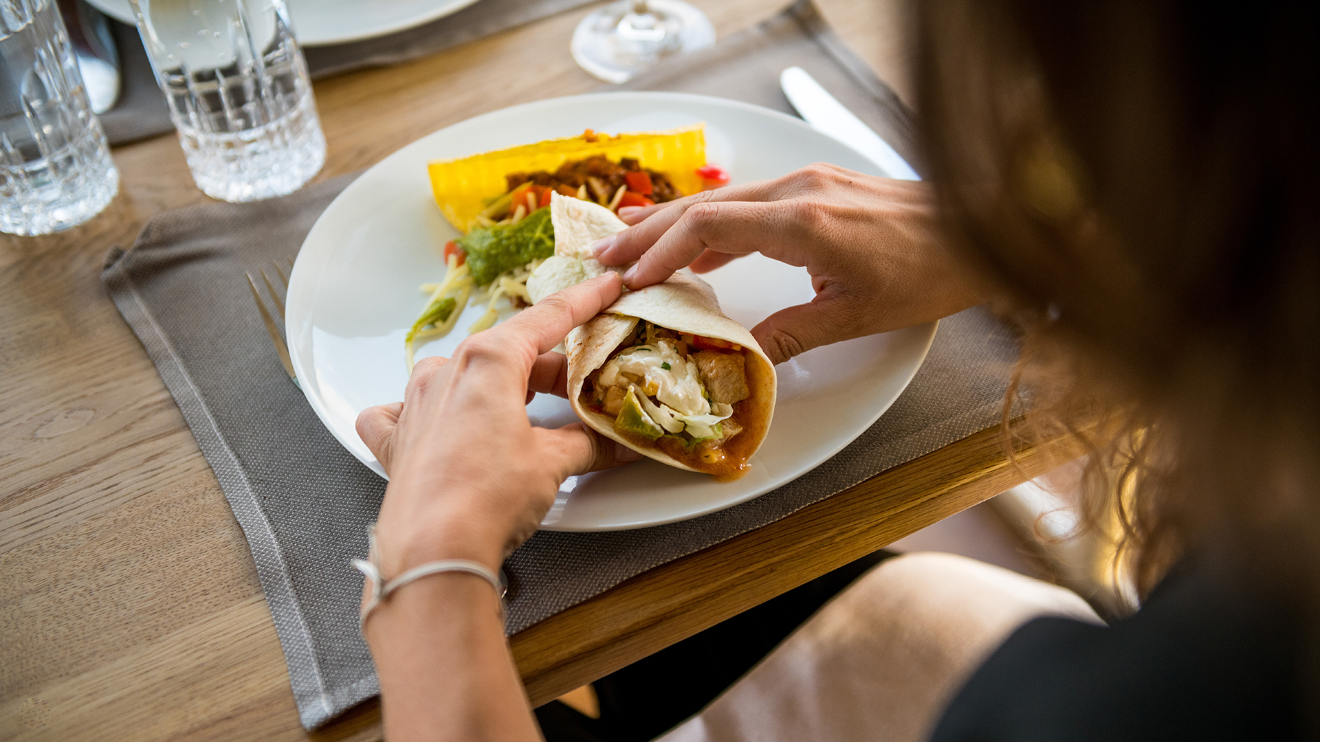 Personne mangeant une fajita à table lors d’un dîner à bord d’un bateau.