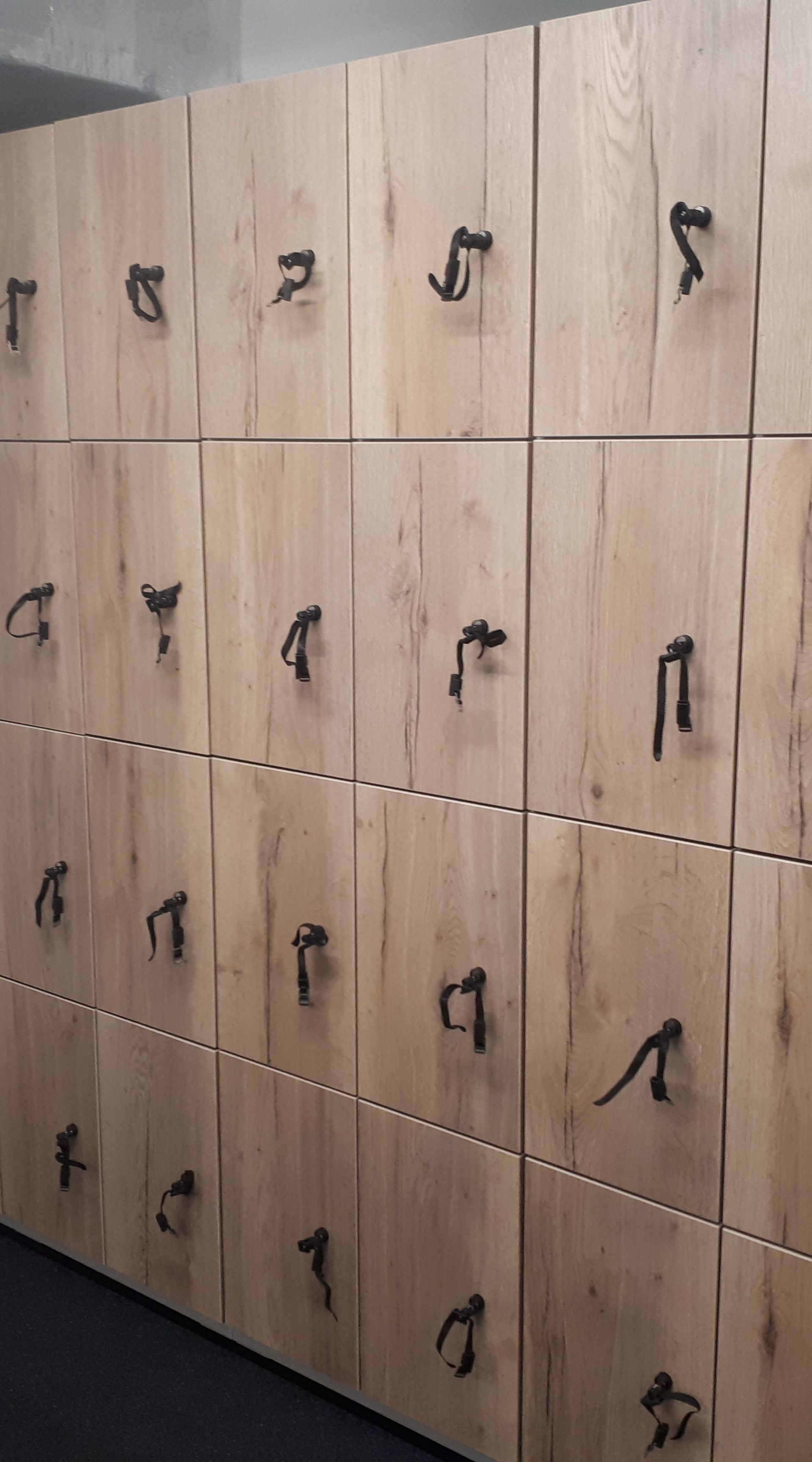 Wooden luggage lockers in an indoor space.