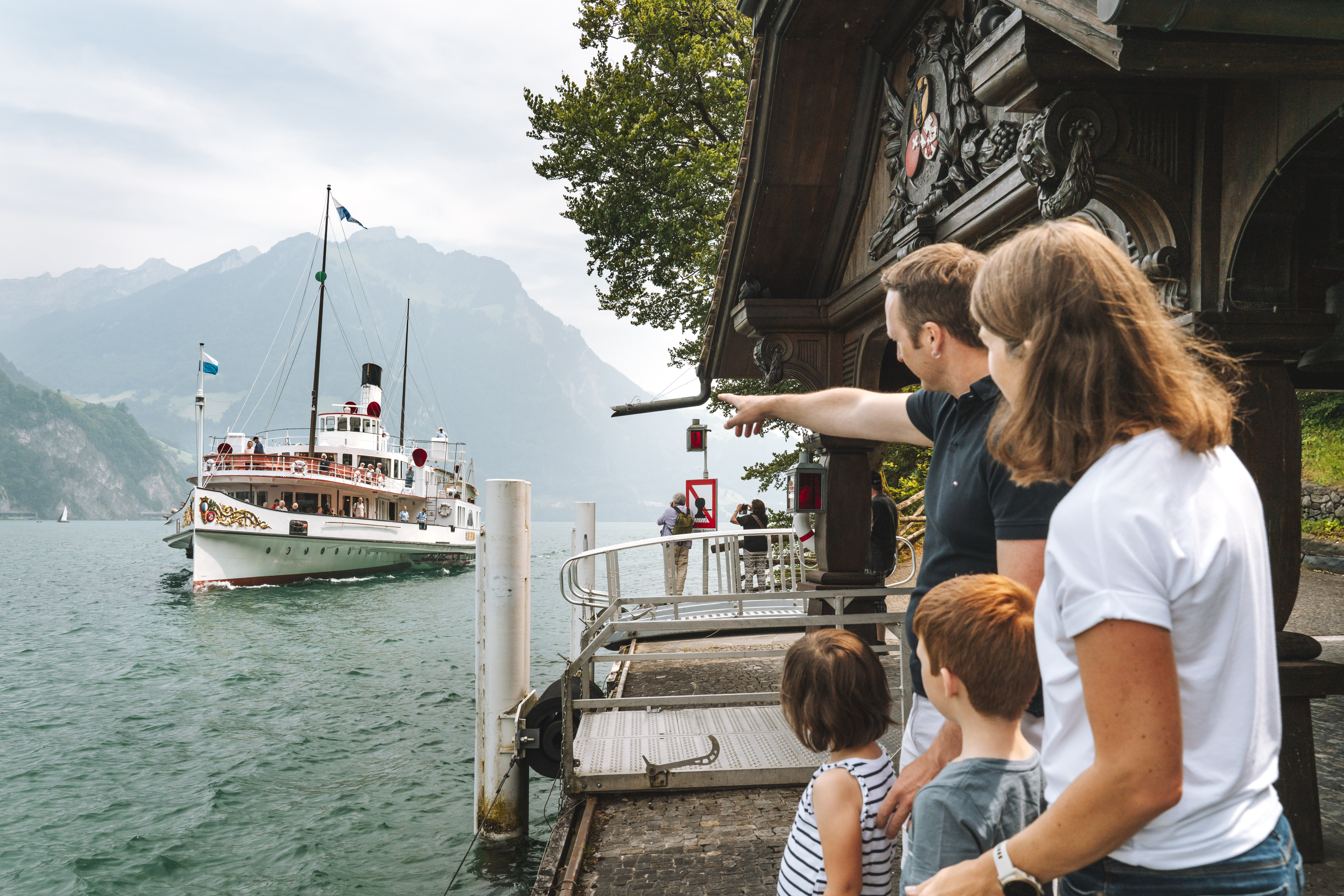 Familie wartet am Steg auf das Dampfschiff