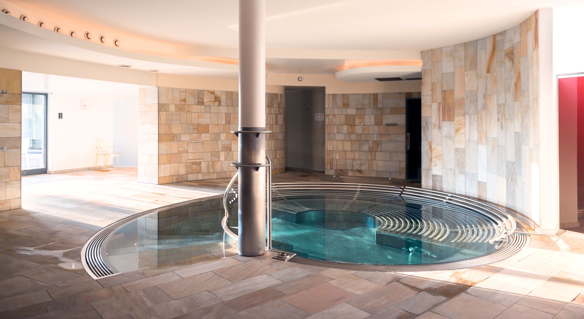 Innenbereich eines Wellnessbereichs mit Pool, moderner Architektur und ruhiger Atmosphäre.