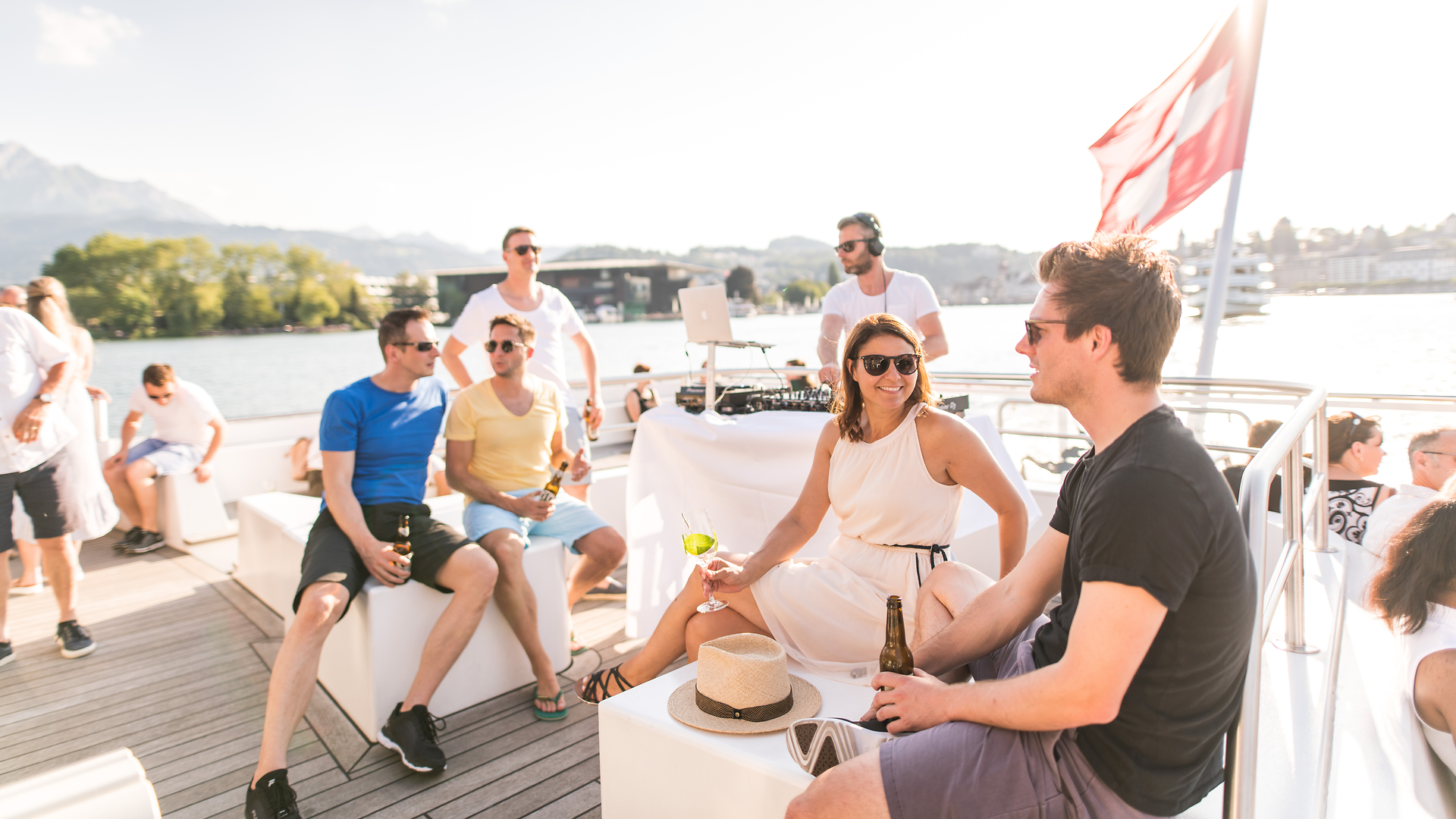 Groupe d’amis assis sur le pont d’un bateau lors d’une soirée estivale.