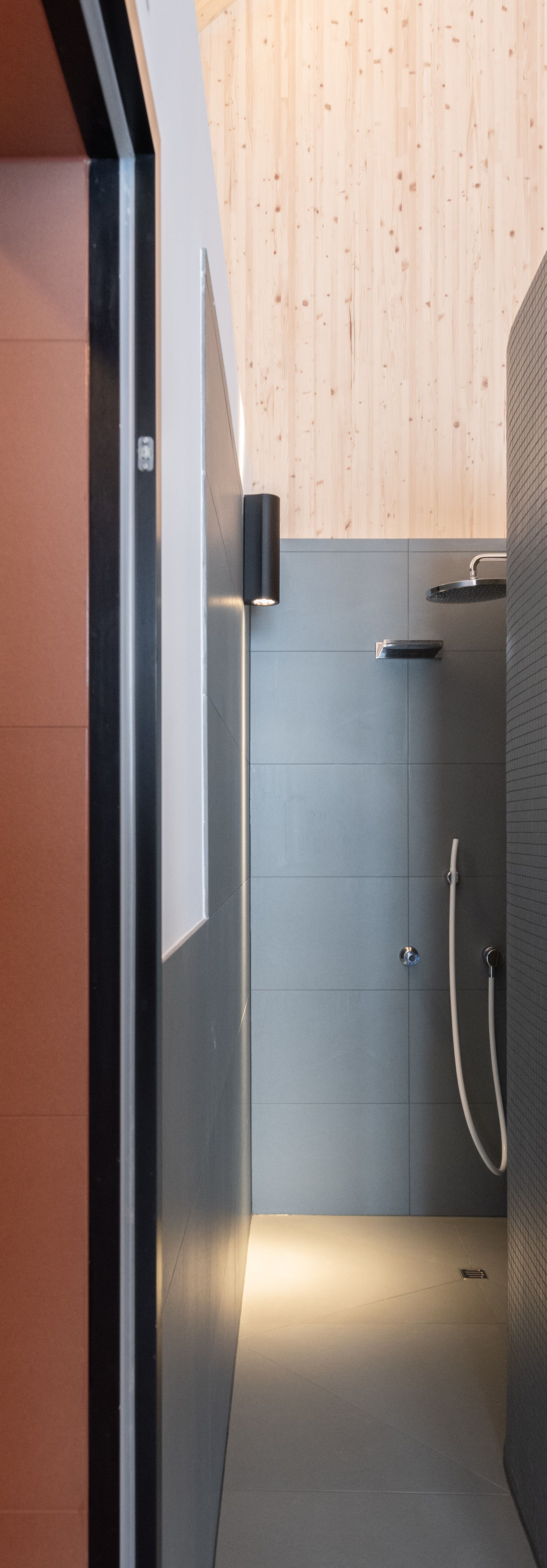Moderner Spa-Innenbereich mit Saunen, Holzfass und stilvoller Beleuchtung.