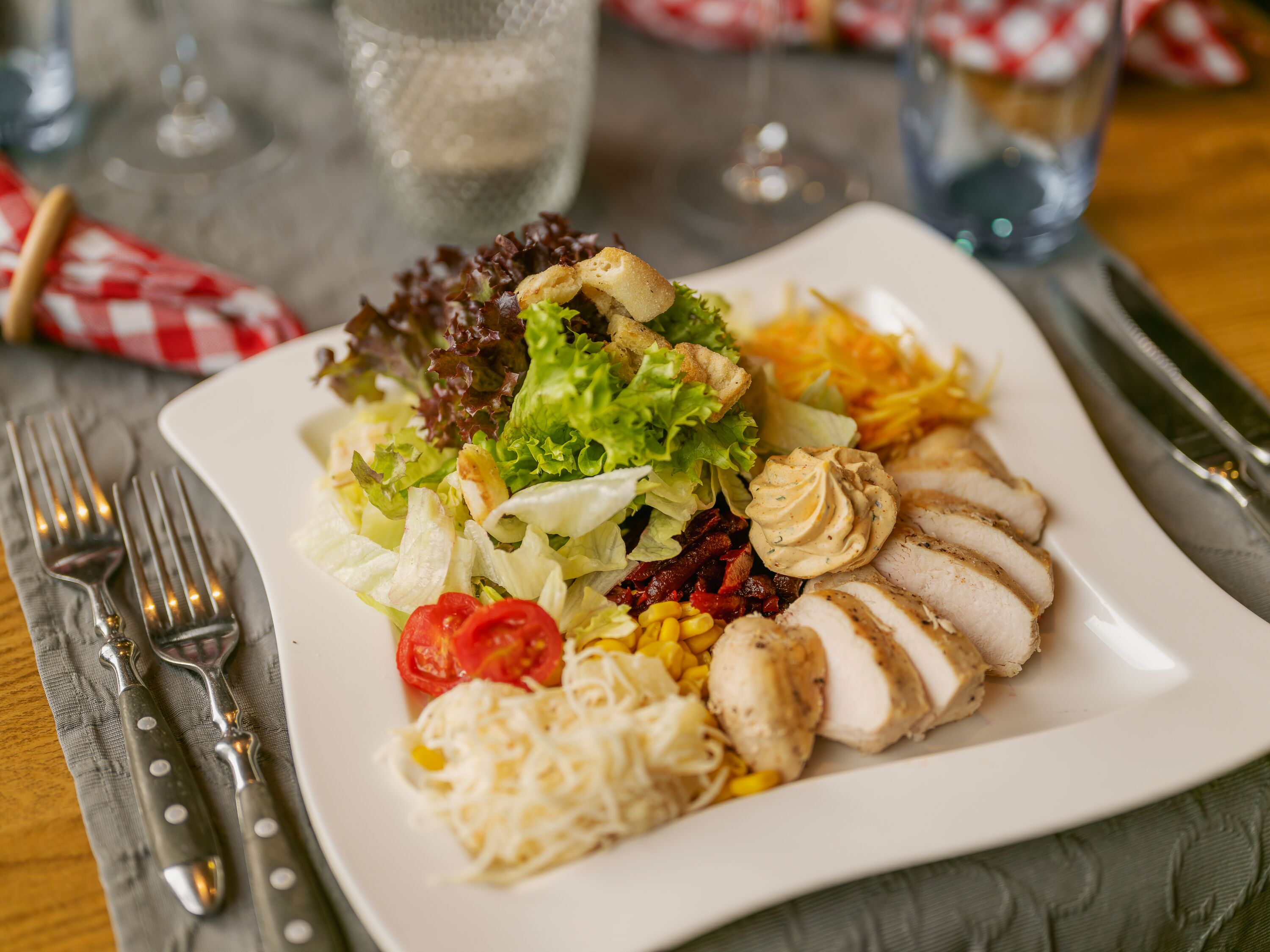 Servierter Teller mit Fleisch, Beilagen und Gemüse in einem Restaurant.