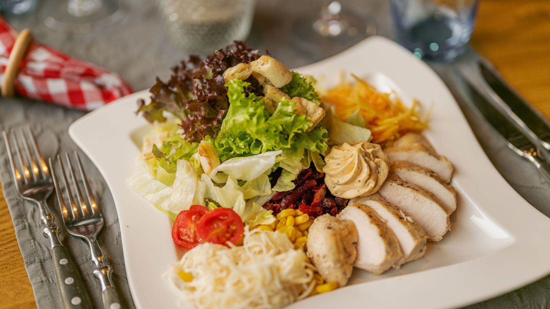 Servierter Teller mit Fleisch, Beilagen und Gemüse in einem Restaurant.