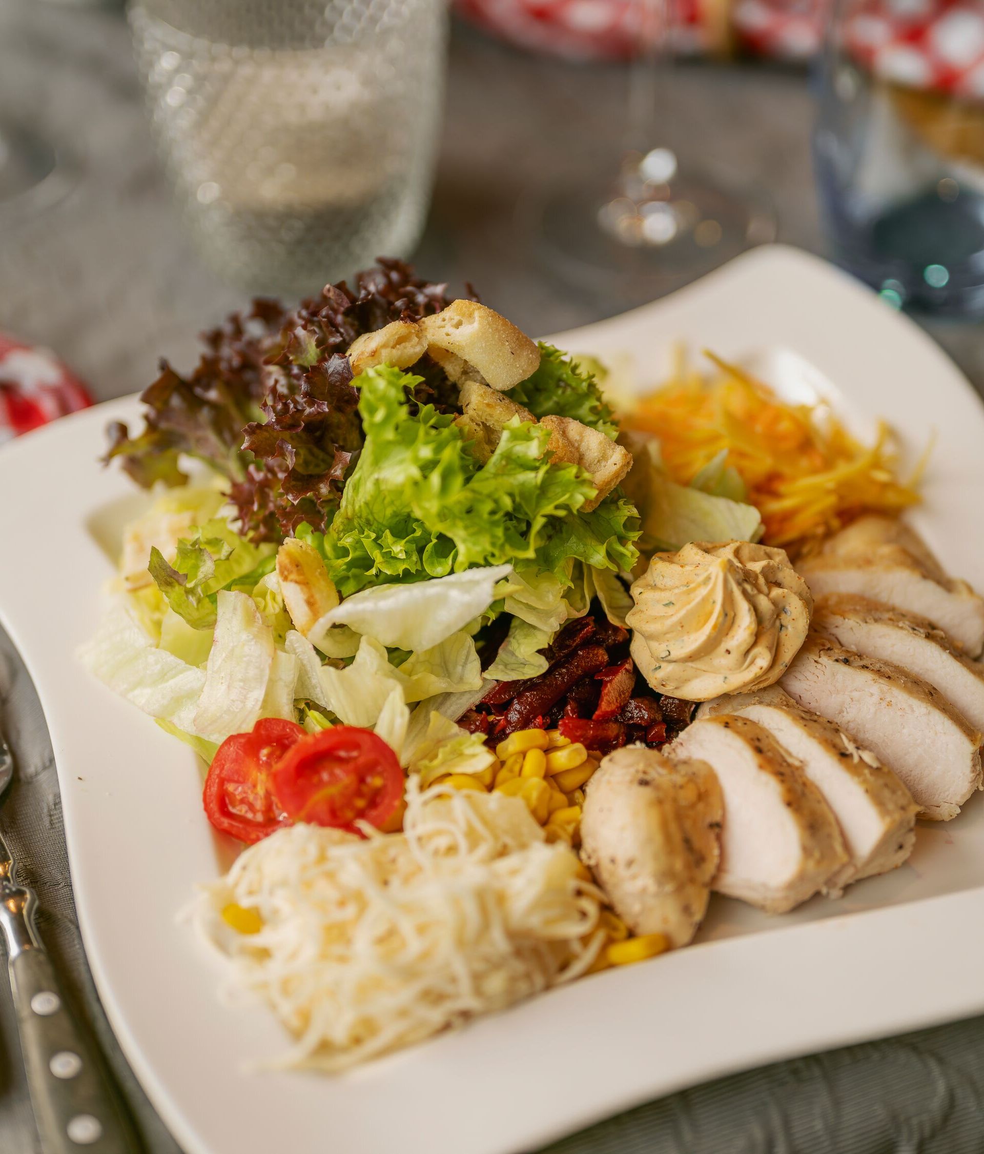 Servierter Teller mit Fleisch, Beilagen und Gemüse in einem Restaurant.