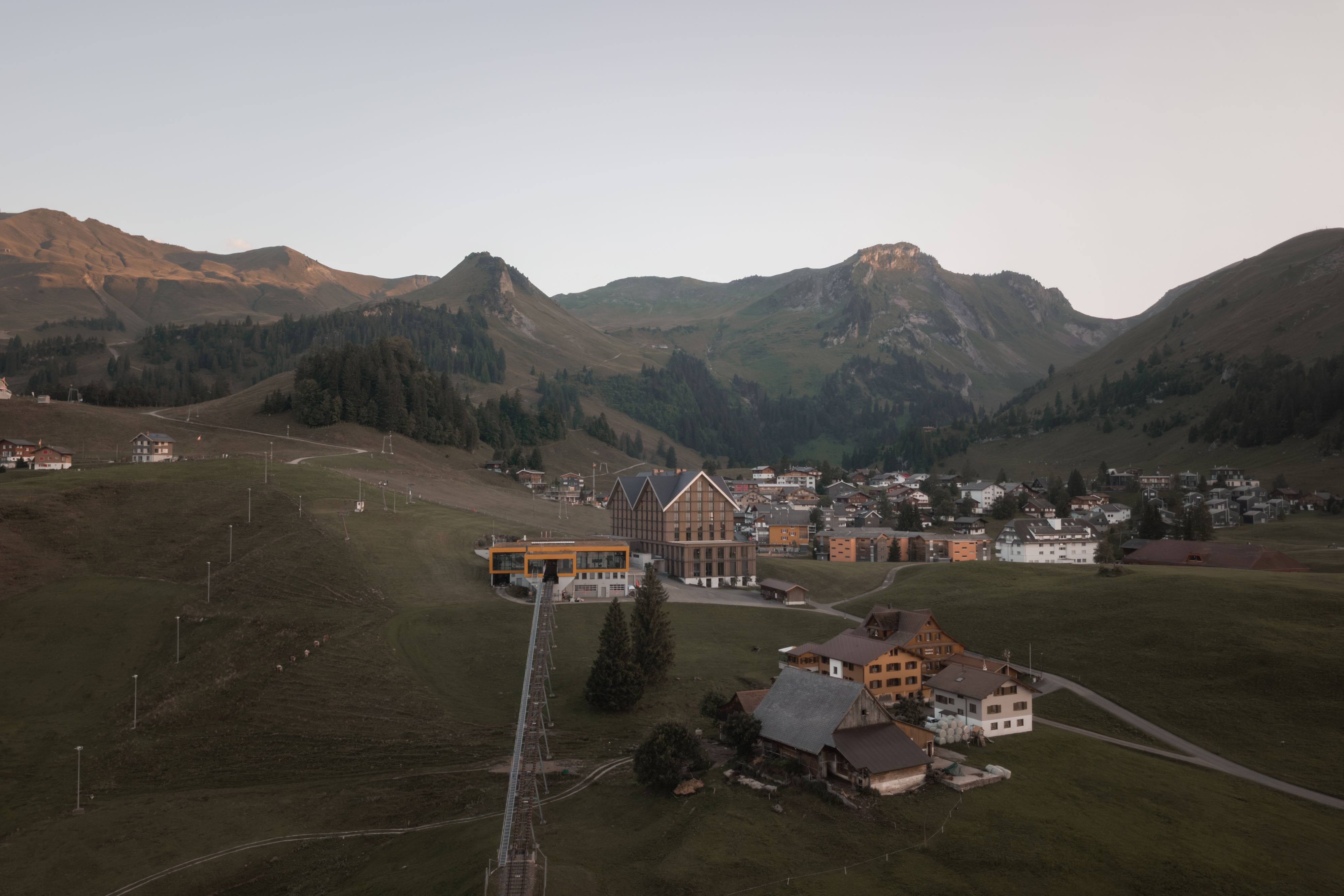 Bergdorf Stoos in alpiner Landschaft mit Häusern und umliegenden Bergen.
