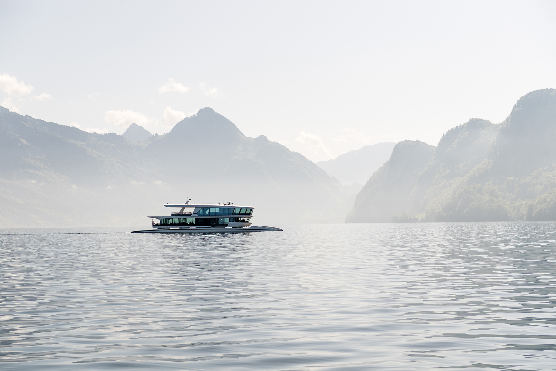 Motor vessel cruising across calm waters on Lake Lucerne surrounded by mountain scenery