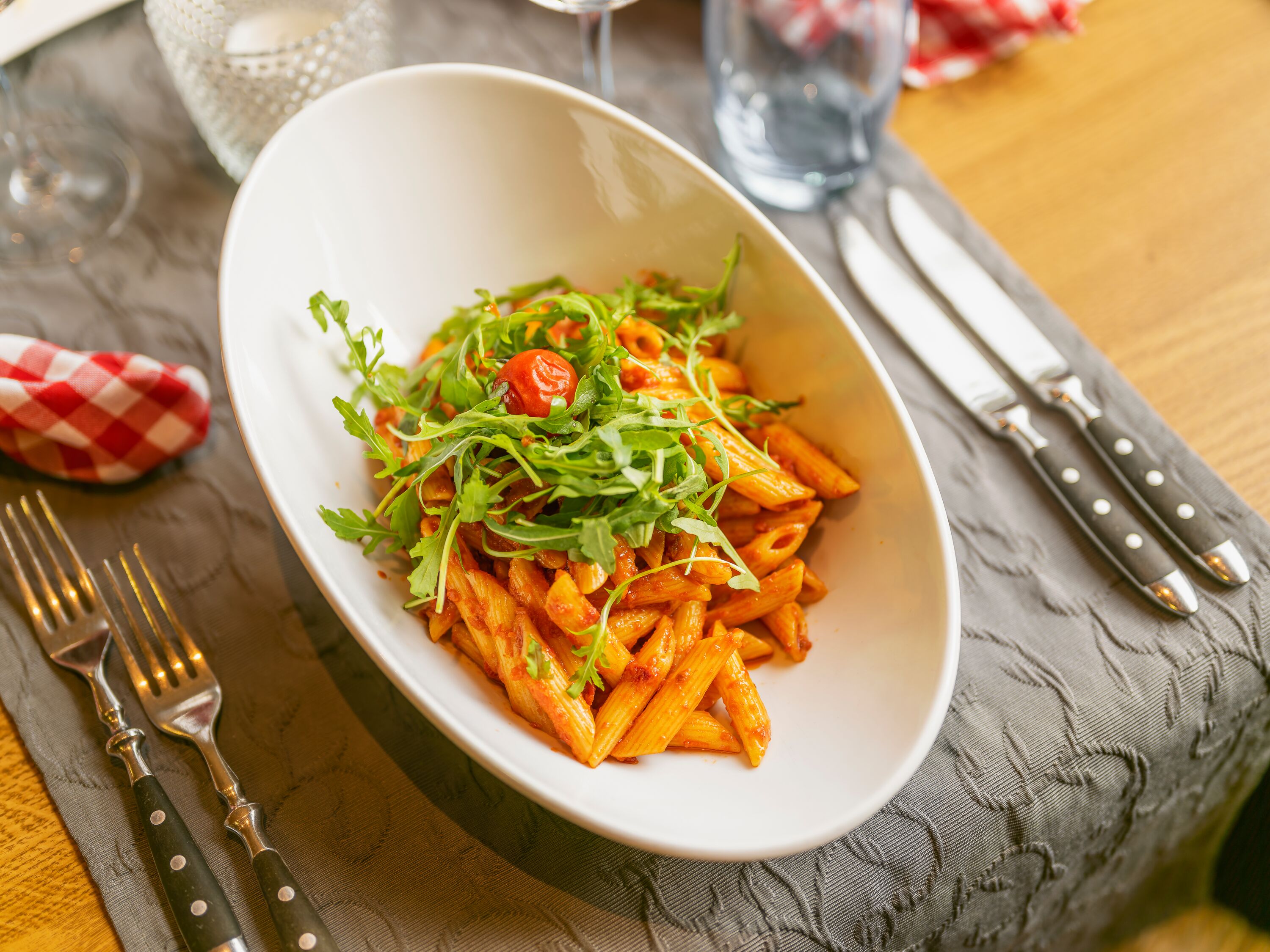 Teller mit Pasta und Gemüse auf einem gedeckten Tisch im Restaurant.
