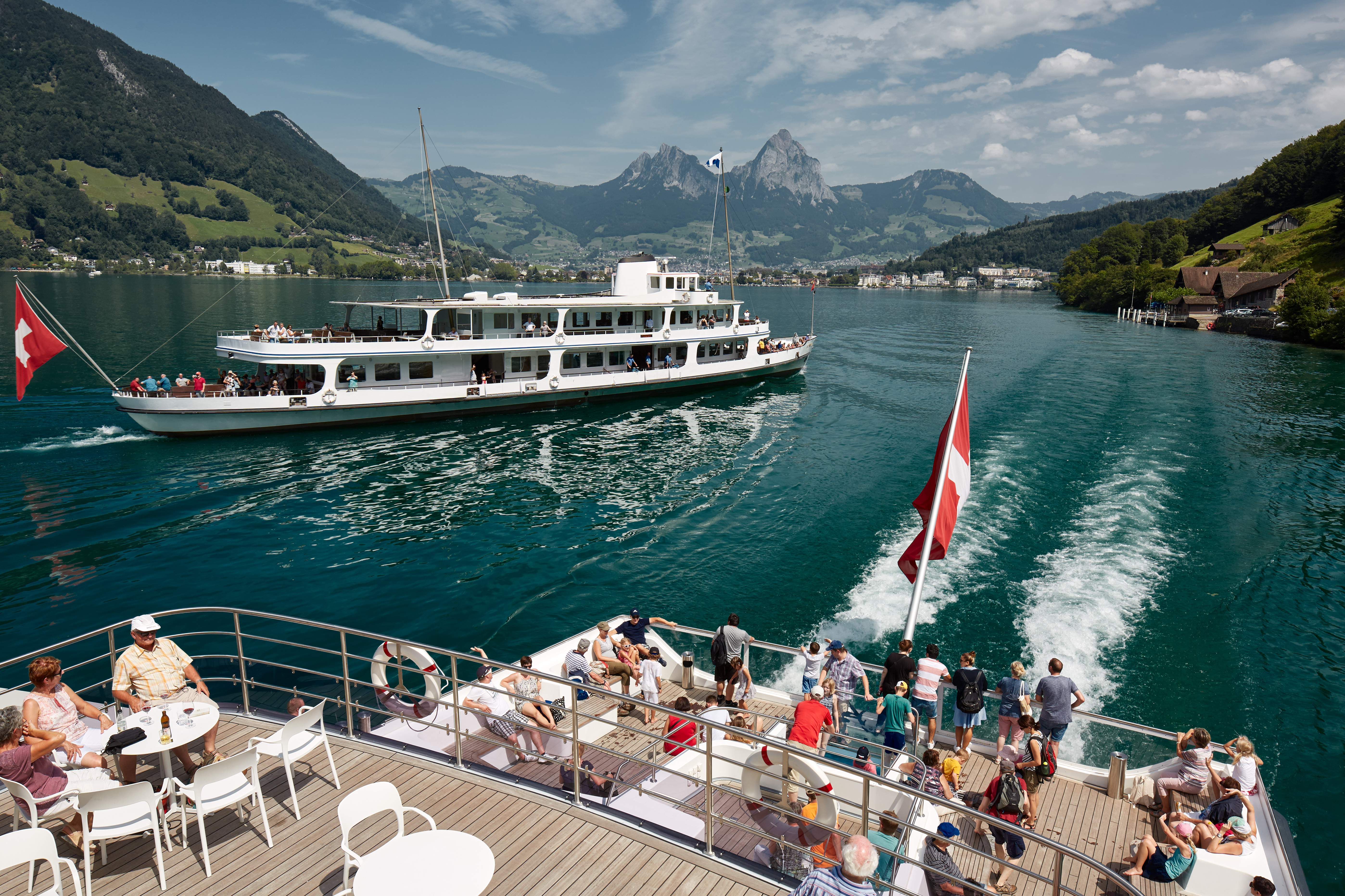 Dampfschiff auf dem Vierwaldstättersee mit Passagieren auf dem Aussendeck und Blick auf die Berglandschaft der Zentralschweiz