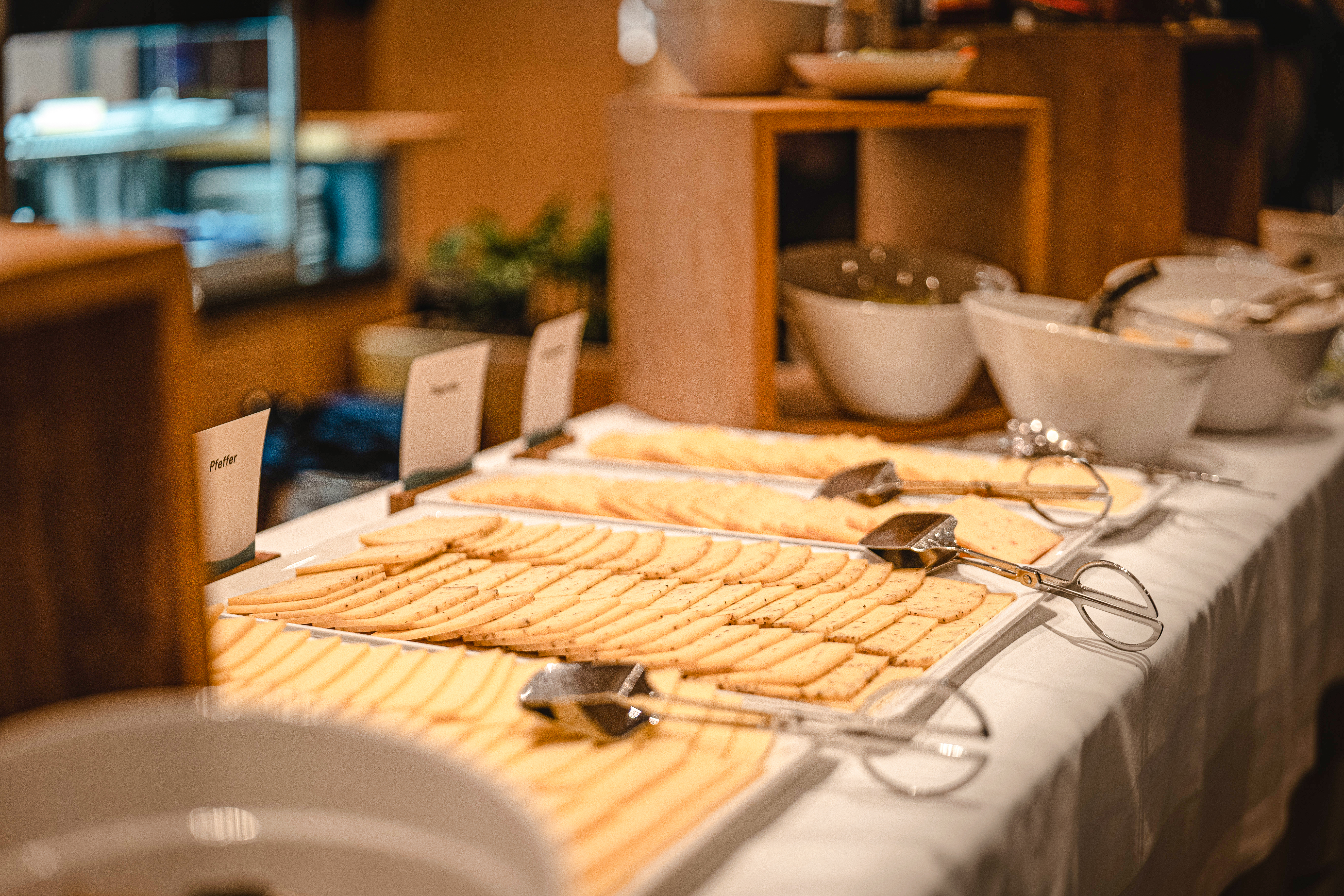 Buffet with cheese fondue, raclette ingredients and side dishes on board a ship.