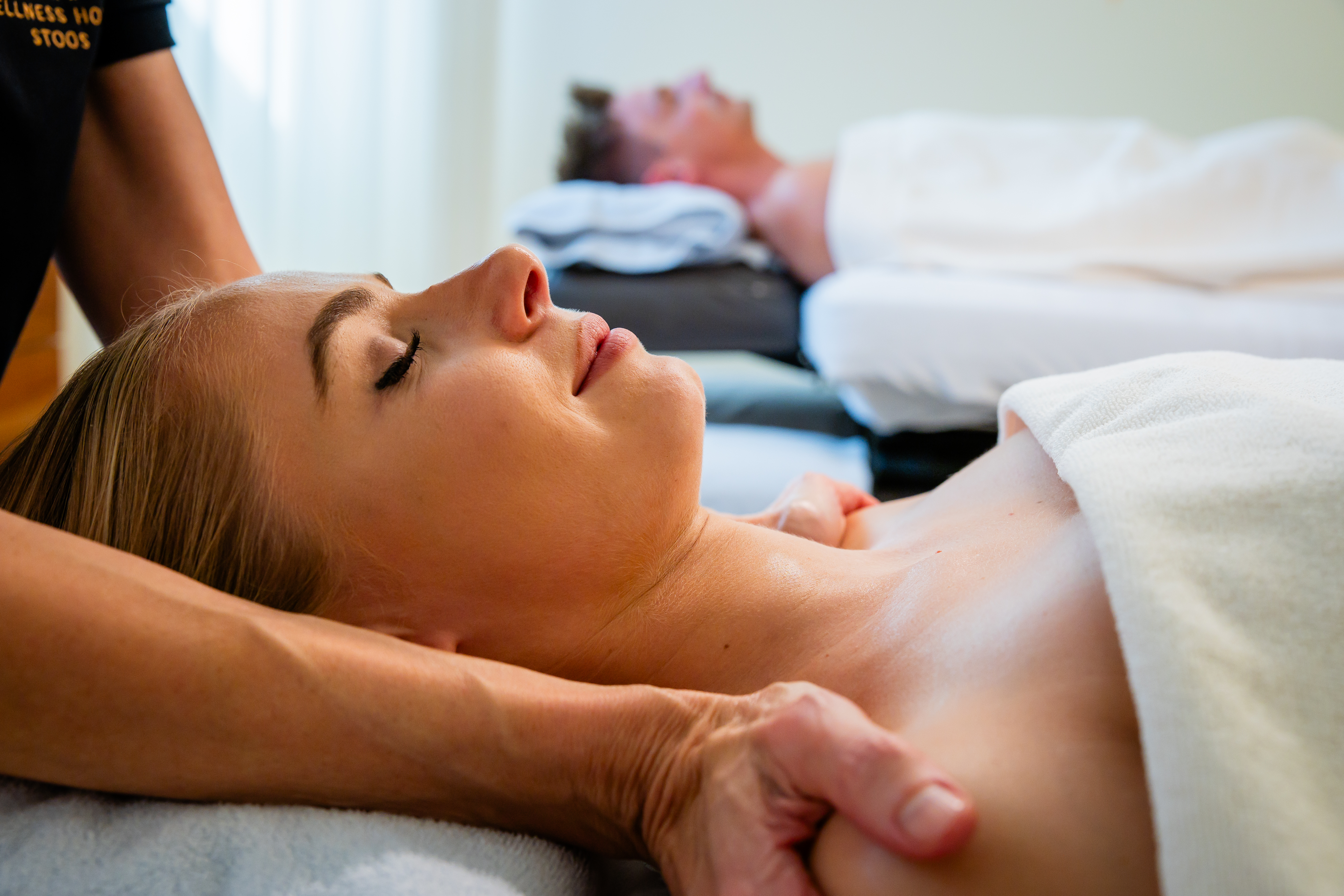 Woman receiving a relaxing neck massage in a calm spa setting.
