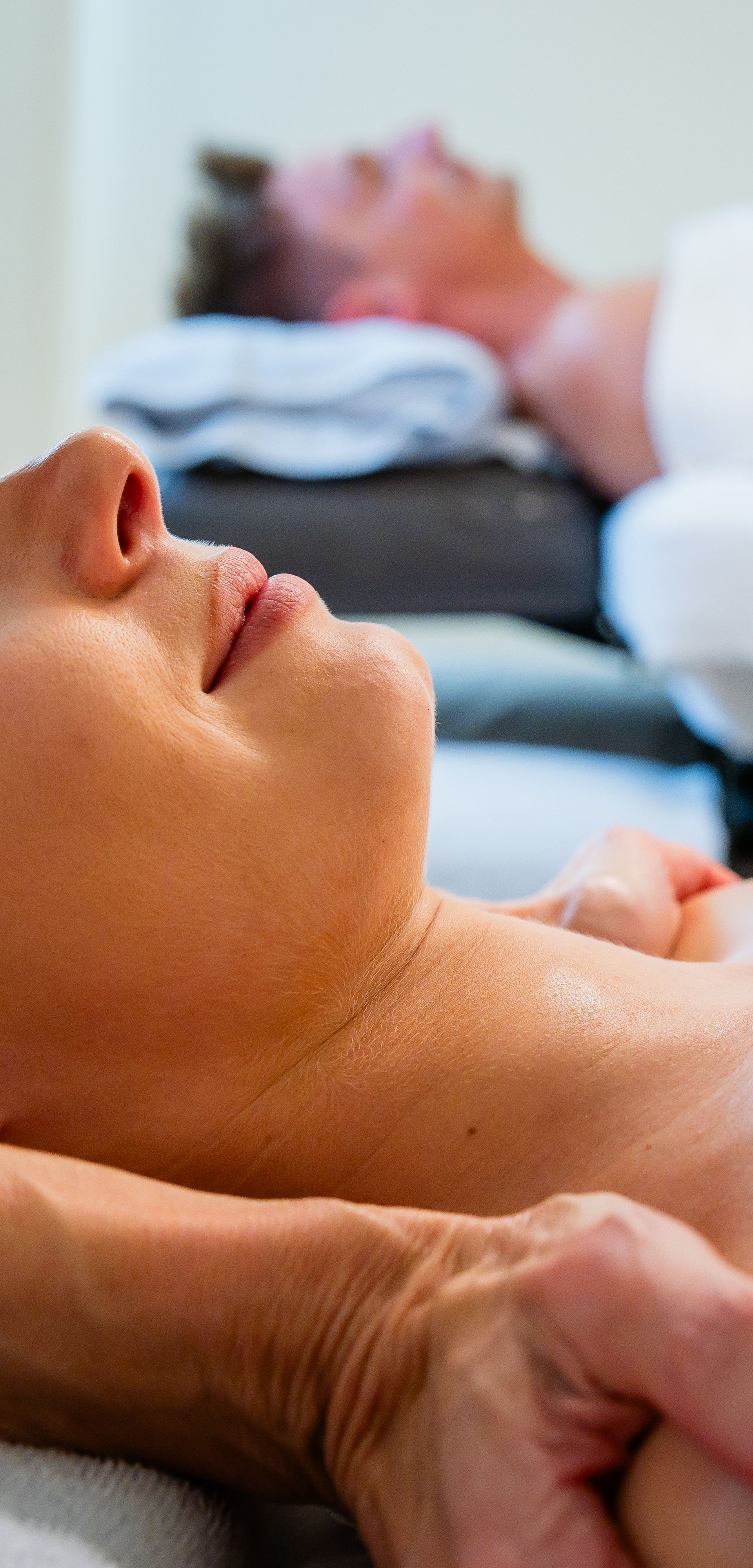 Frau erhält eine entspannende Nackenmassage in ruhiger Spa-Atmosphäre.