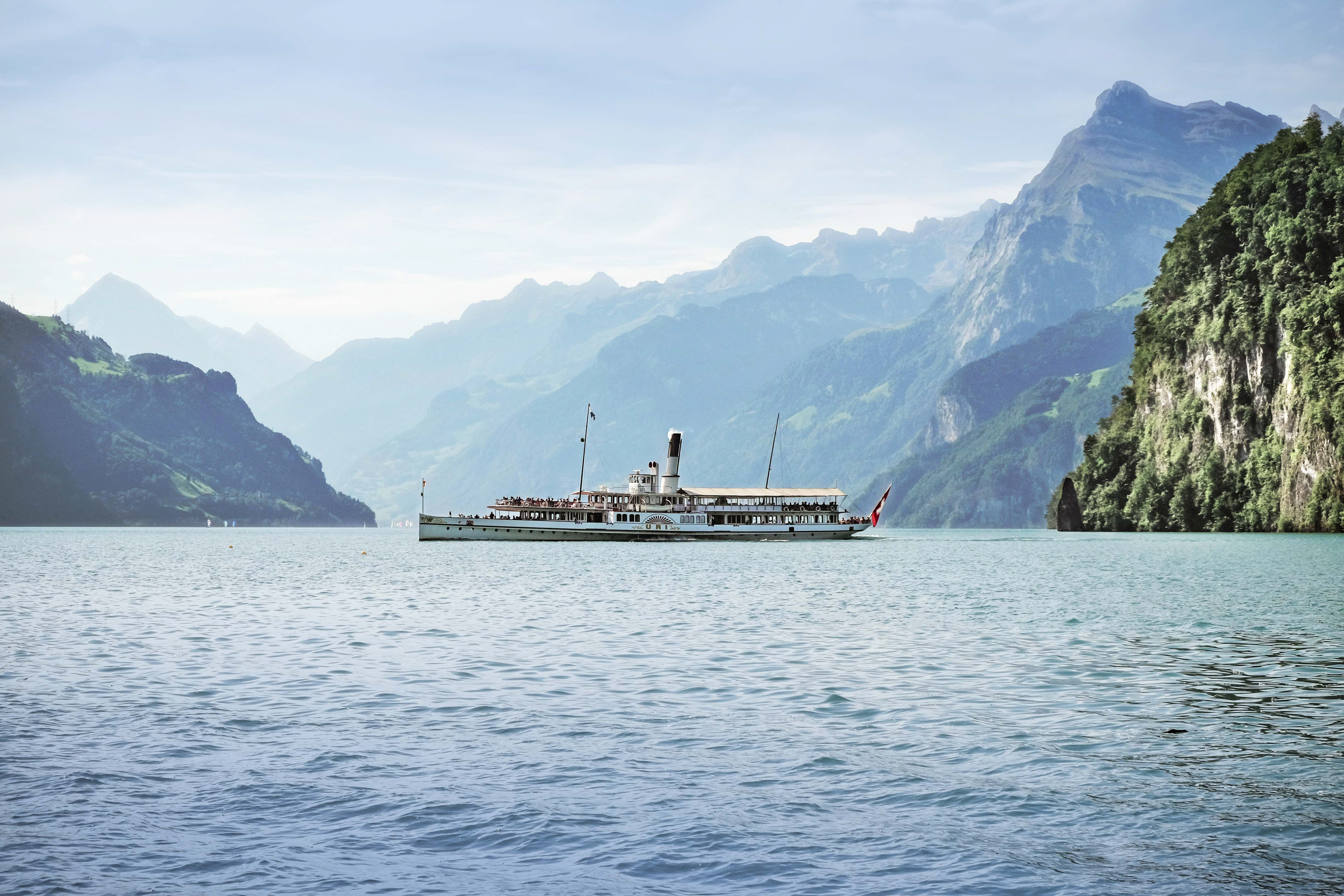Historic steamboat cruising on Lake Lucerne during the grand lake cruise with mountain scenery.