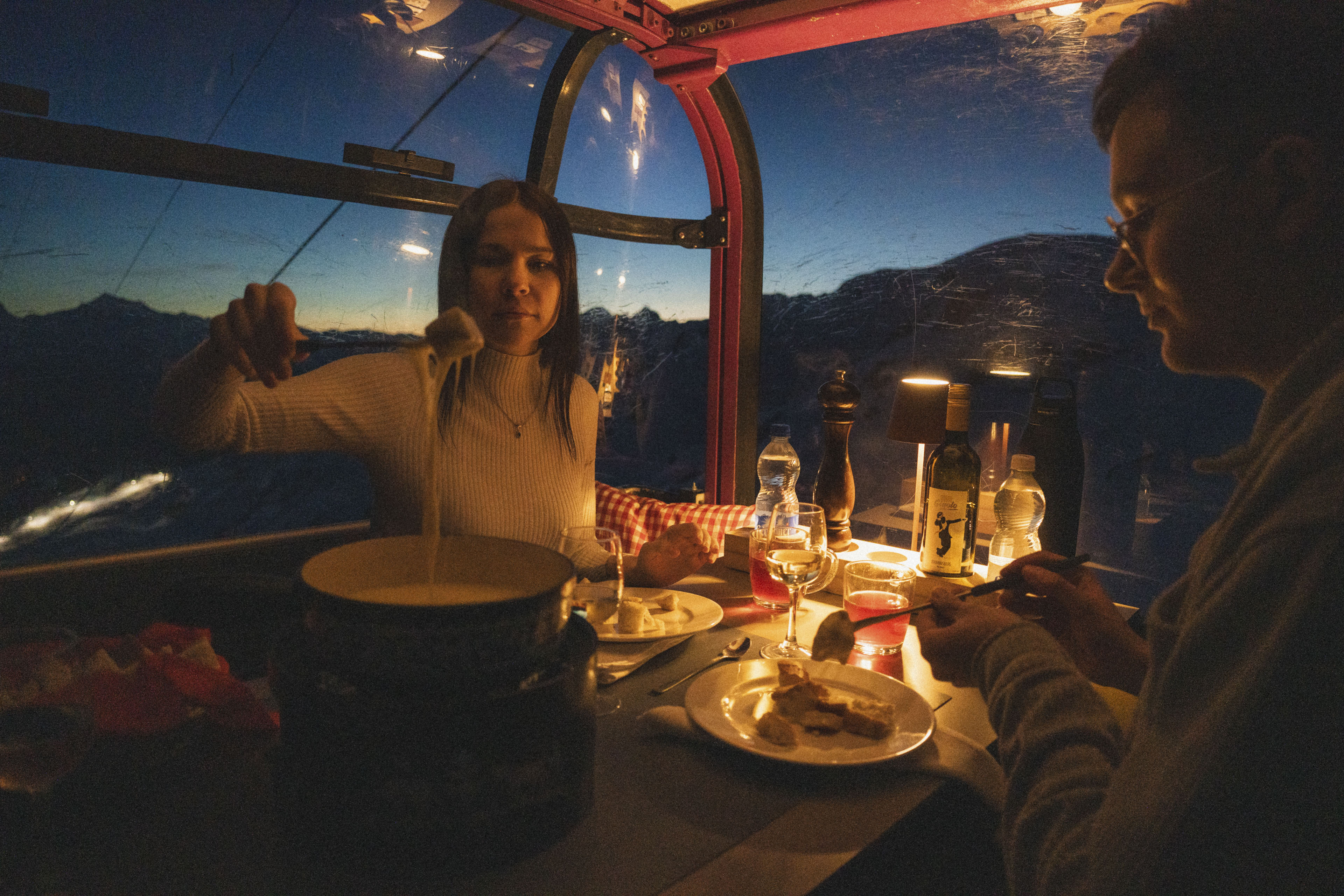 Ein Paar isst Fondue in der Fonduegondel Bettmerhorn