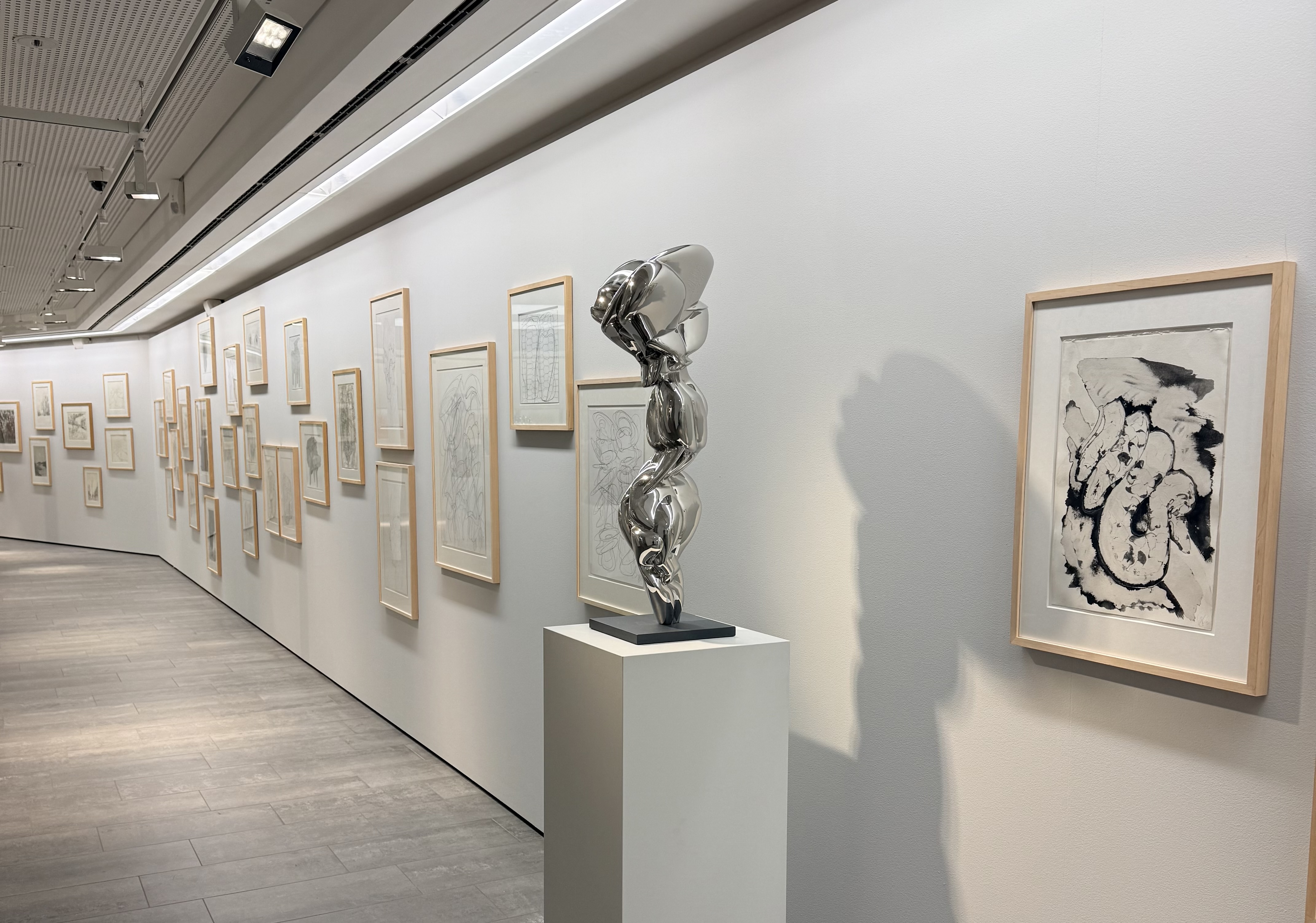 Ausstellungsraum mit Zeichnungen und einer Edelstahlskulptur von Tony Cragg im Olaf Gulbransson Museum Tegernsee