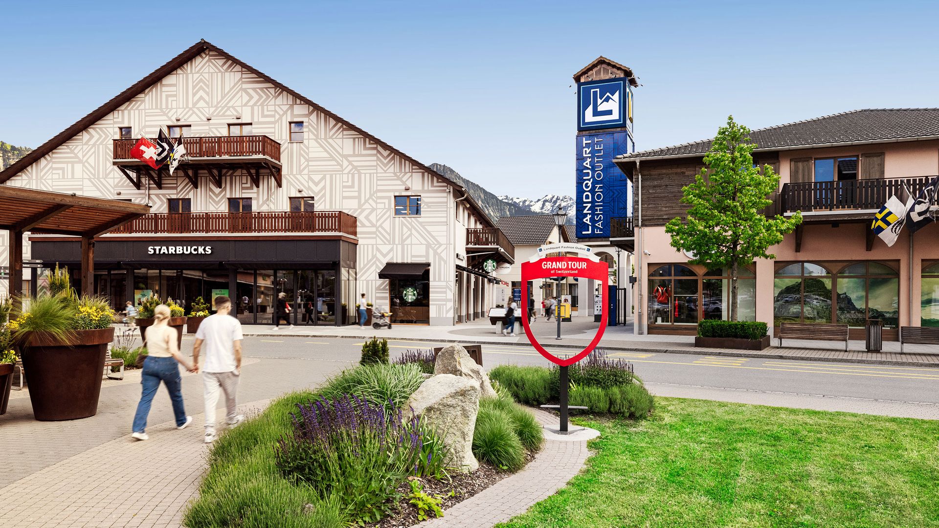 The entrance area of a shopping centre with people walking around.