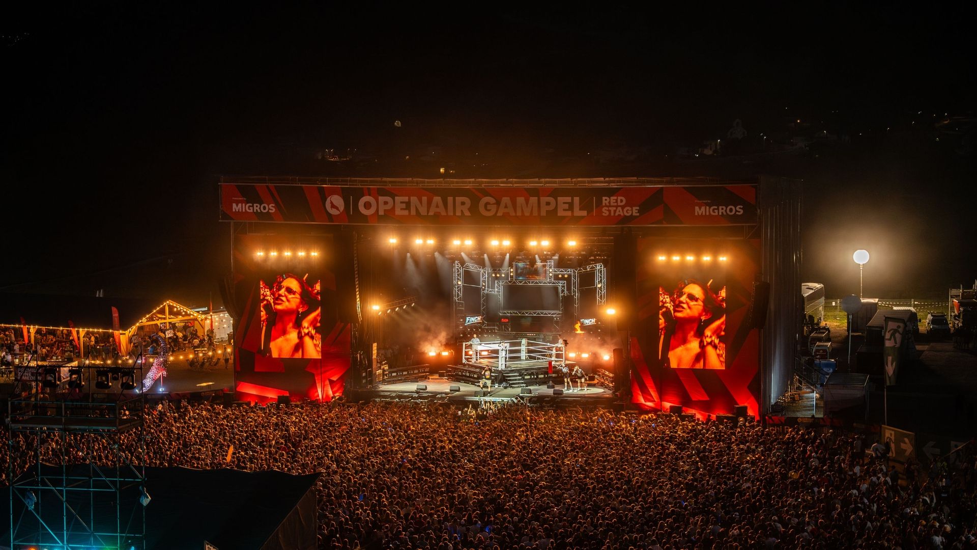 Menschenmenge vor der Bühne am Openair Gampel bei einem Live-Konzert mit Lichtshow.
