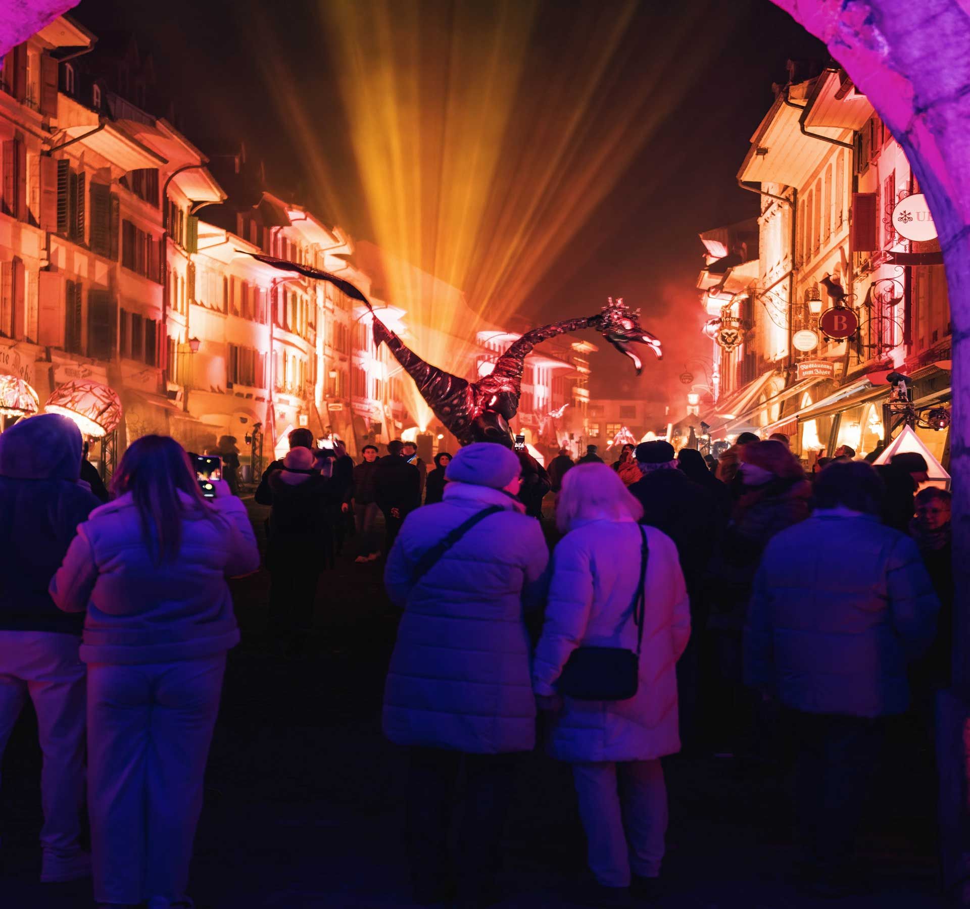 Vue sur le Festival des Lumières de Morat avec des lumières violettes illuminant la vieille ville historique.