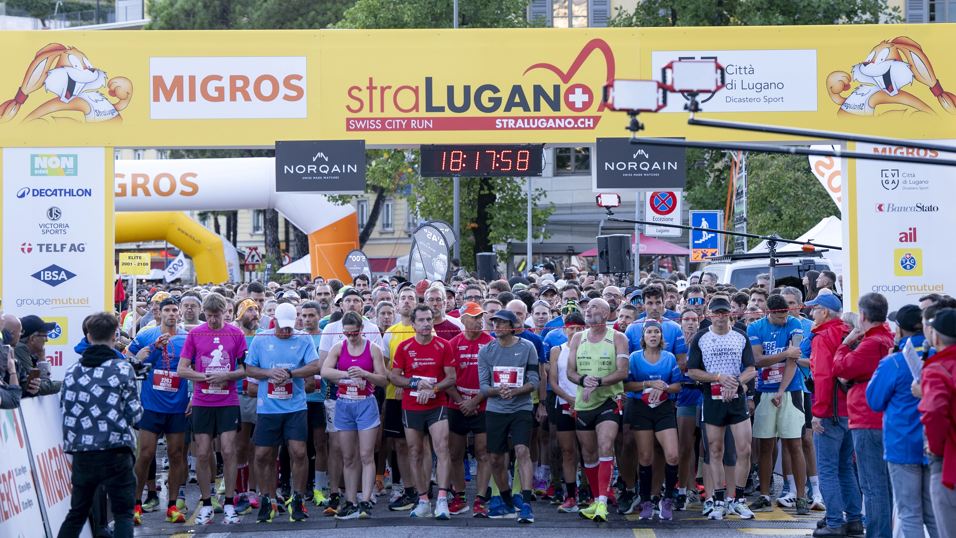 Participants at the StraLugano starting line shortly before the start, with spectators and an urban backdrop.