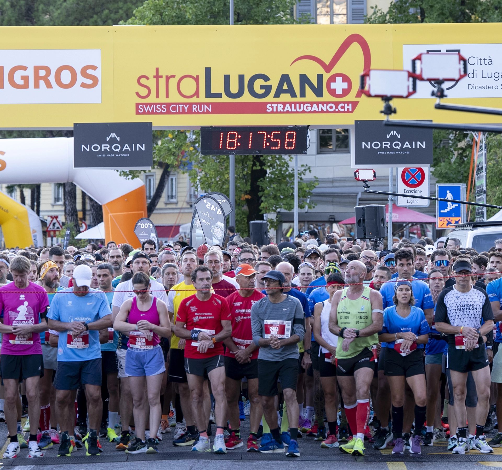 Participants at the StraLugano starting line shortly before the start, with spectators and an urban backdrop.